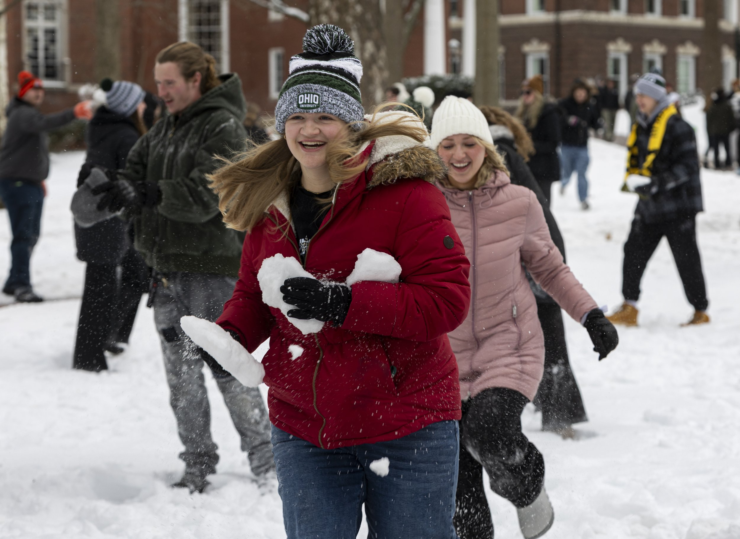 Students run down Ohio University's College Green during a large snowball fight in Athens, Ohio, Jan. 26, 2026. The university canceled classes for two days due to heavy snow. Hundreds of students gathered on College Green during their rare off-day f