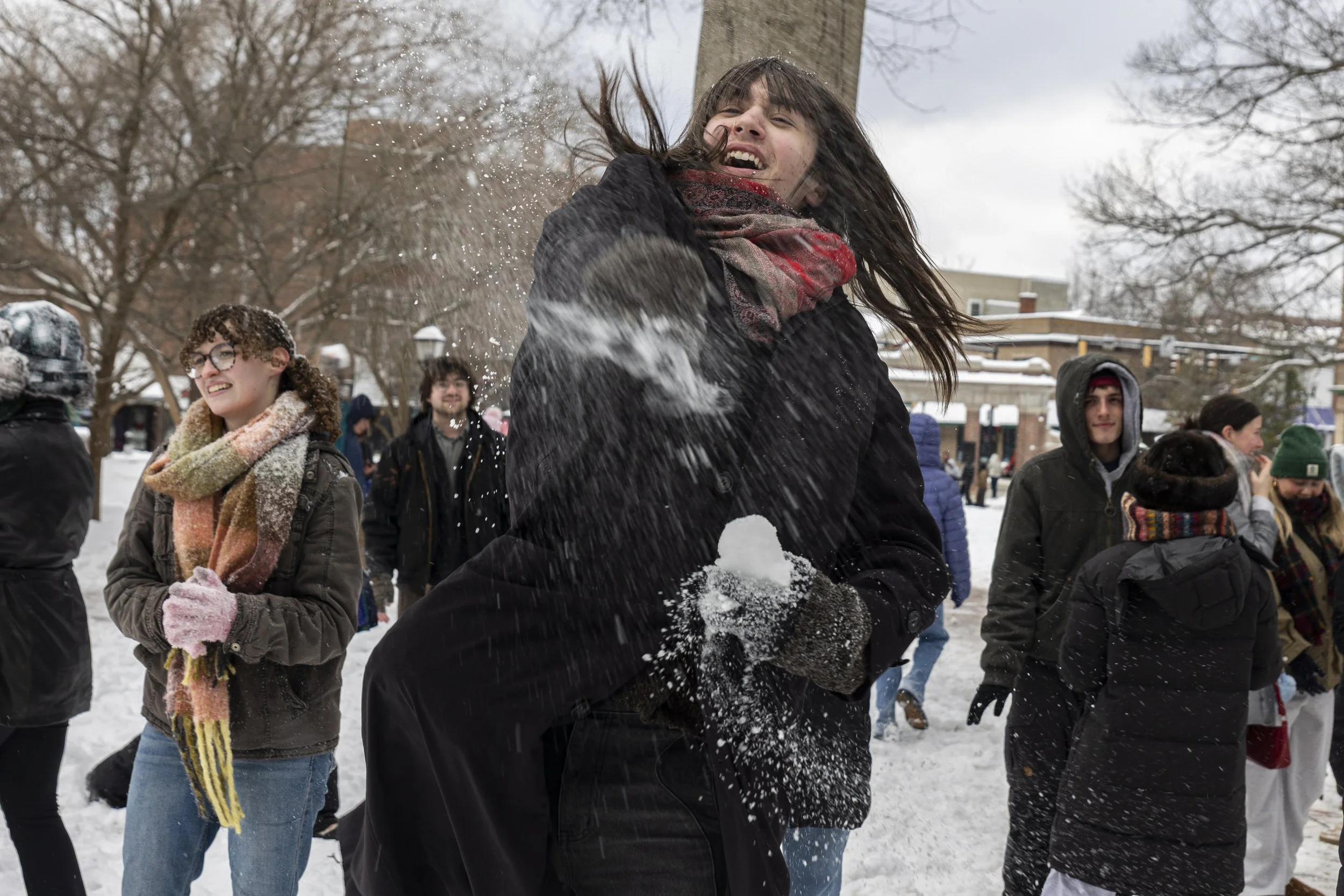 Alex Dooley throws a snowball during a large snowball fight on Ohio University's College Green in Athens, Ohio, Jan. 26, 2026. The university canceled classes for two days due to heavy snow. Hundreds of students gathered on College Green during their