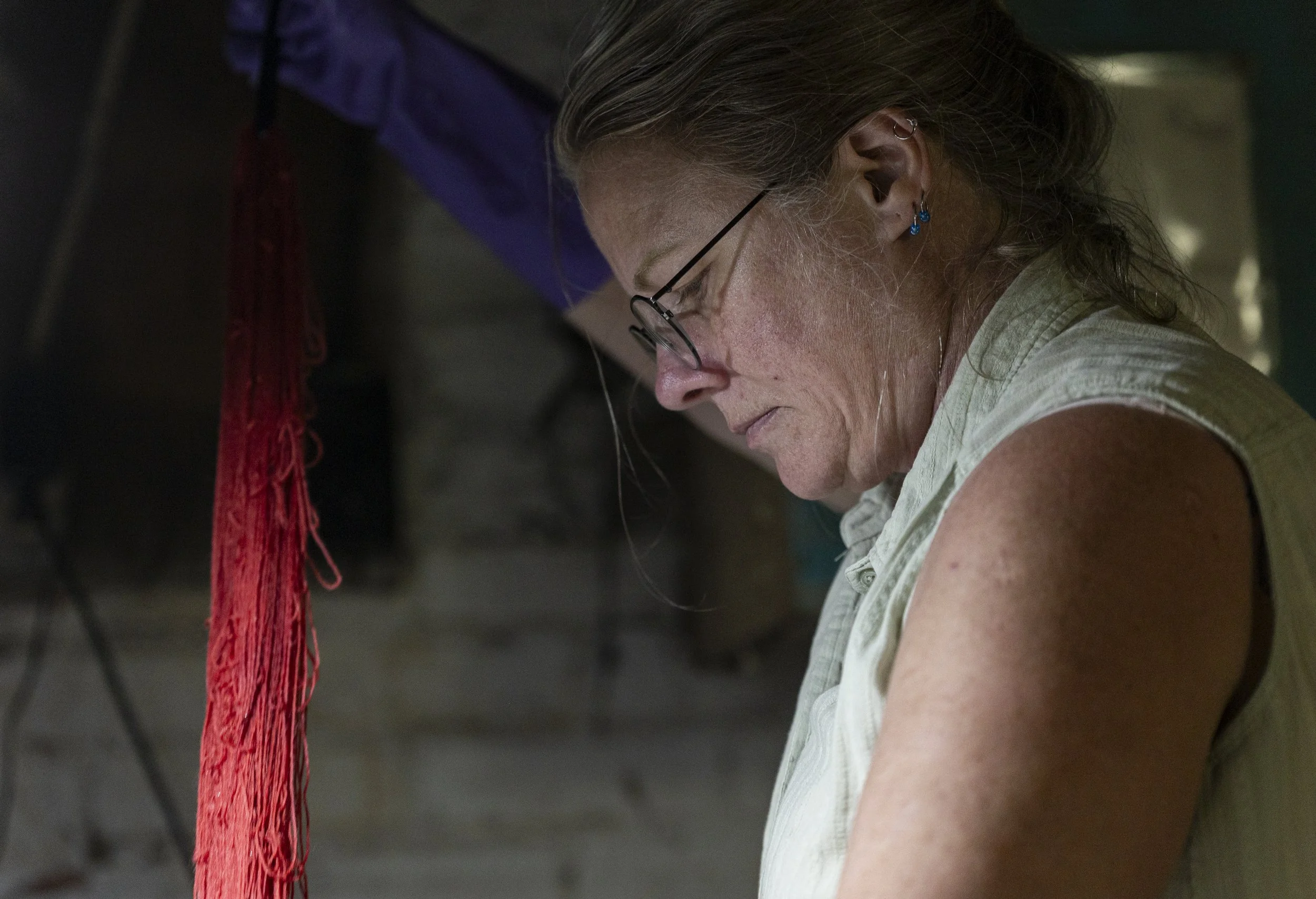 Lisa Heinz pulls a red skein of yarn out of the sink in her basement in Athens, Ohio, September 4, 2025. Along with her pre-made work, Heinz works with clients for custom dyes. The client who ordered this skein wanted a particularly vibrant shade of