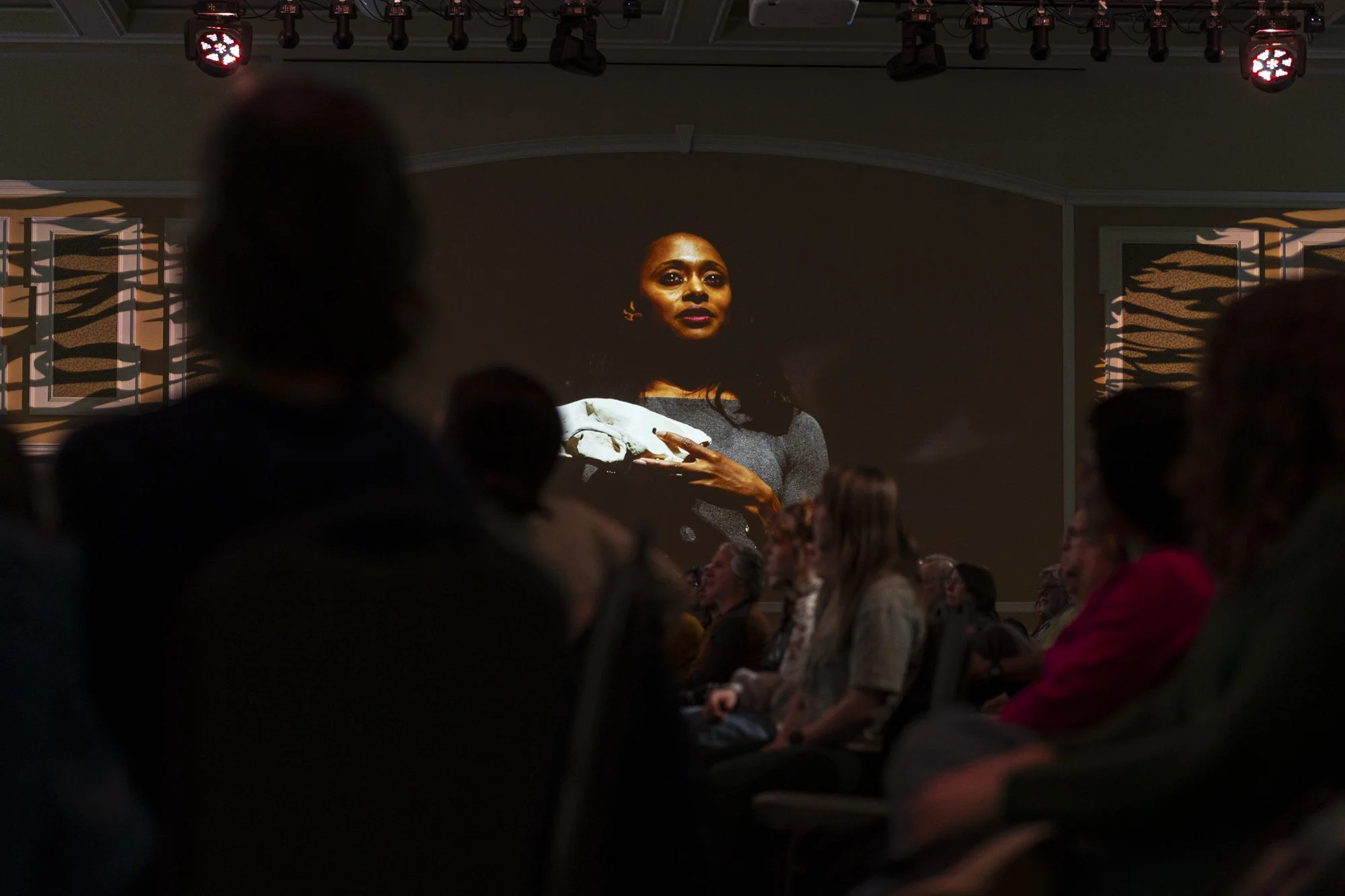 Audience members listen as an image of Dr. Rae Wynn-Grant is projected on the walls during her speech at the Baker Ballroom in the Baker University Center in Athens, Ohio, Feb. 4, 2025. | For The Post