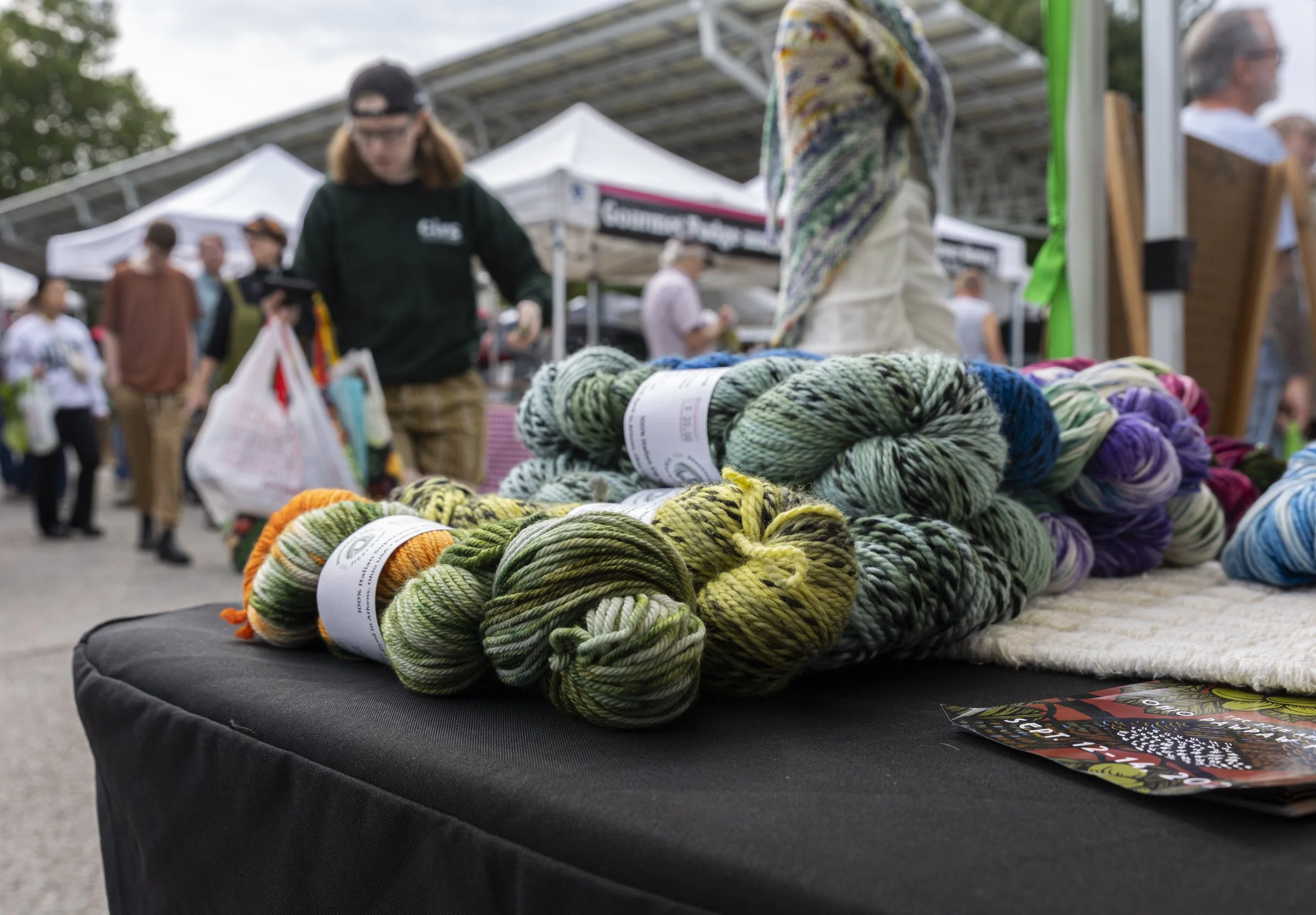 Skeins of dyed yarn sit on a table at Lisa Heinz' booth at the Athens Art and Farmers Market at the Athens Community Center in Athens, Ohio, September 6, 2025. She attends the market most weeks, but is preparing for Pawpaw Festival, one of her busies