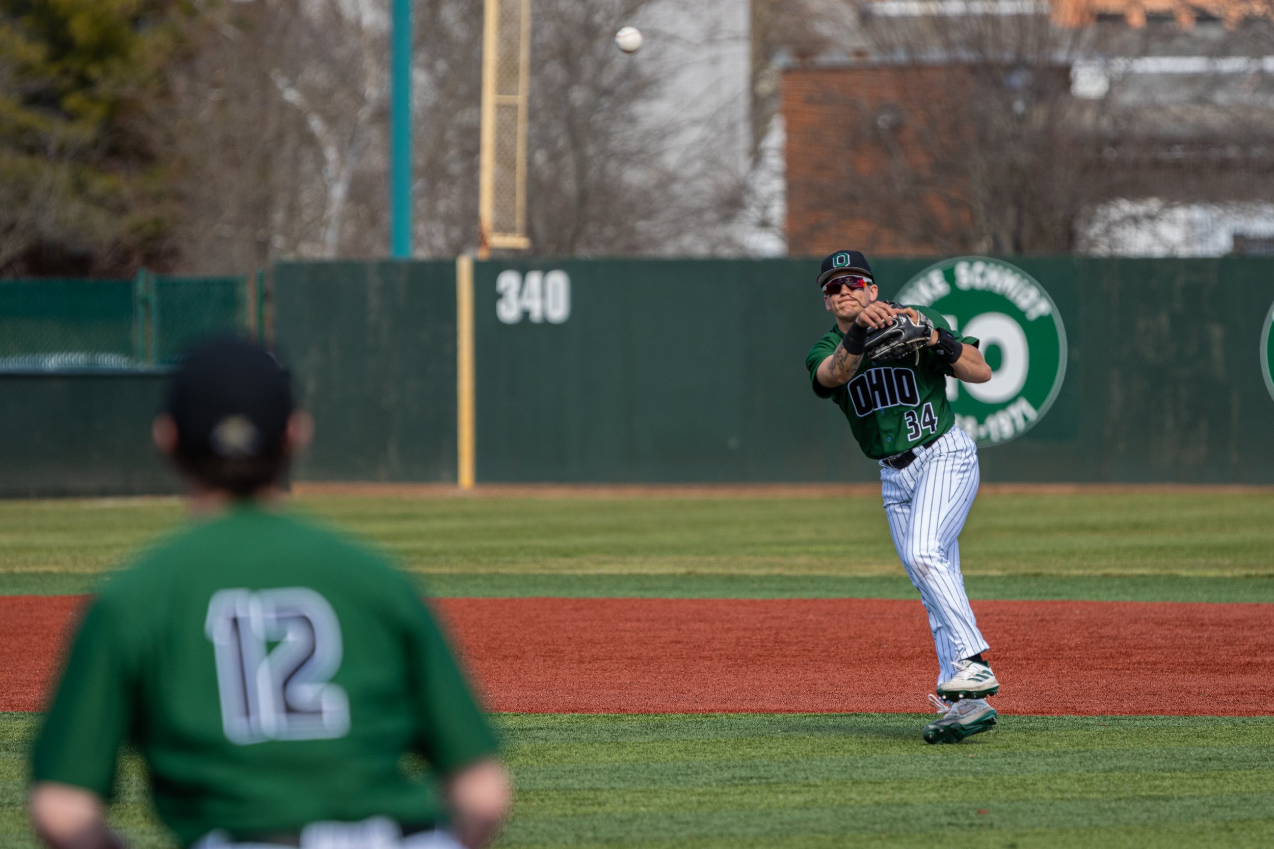 Ohio Bobcats infielder JR Nelson (34) throws the ball to infielder Bryce Smith (12) against UIC at Wren Stadium in Athens, Mar. 3, 2024. | Shot for The Post