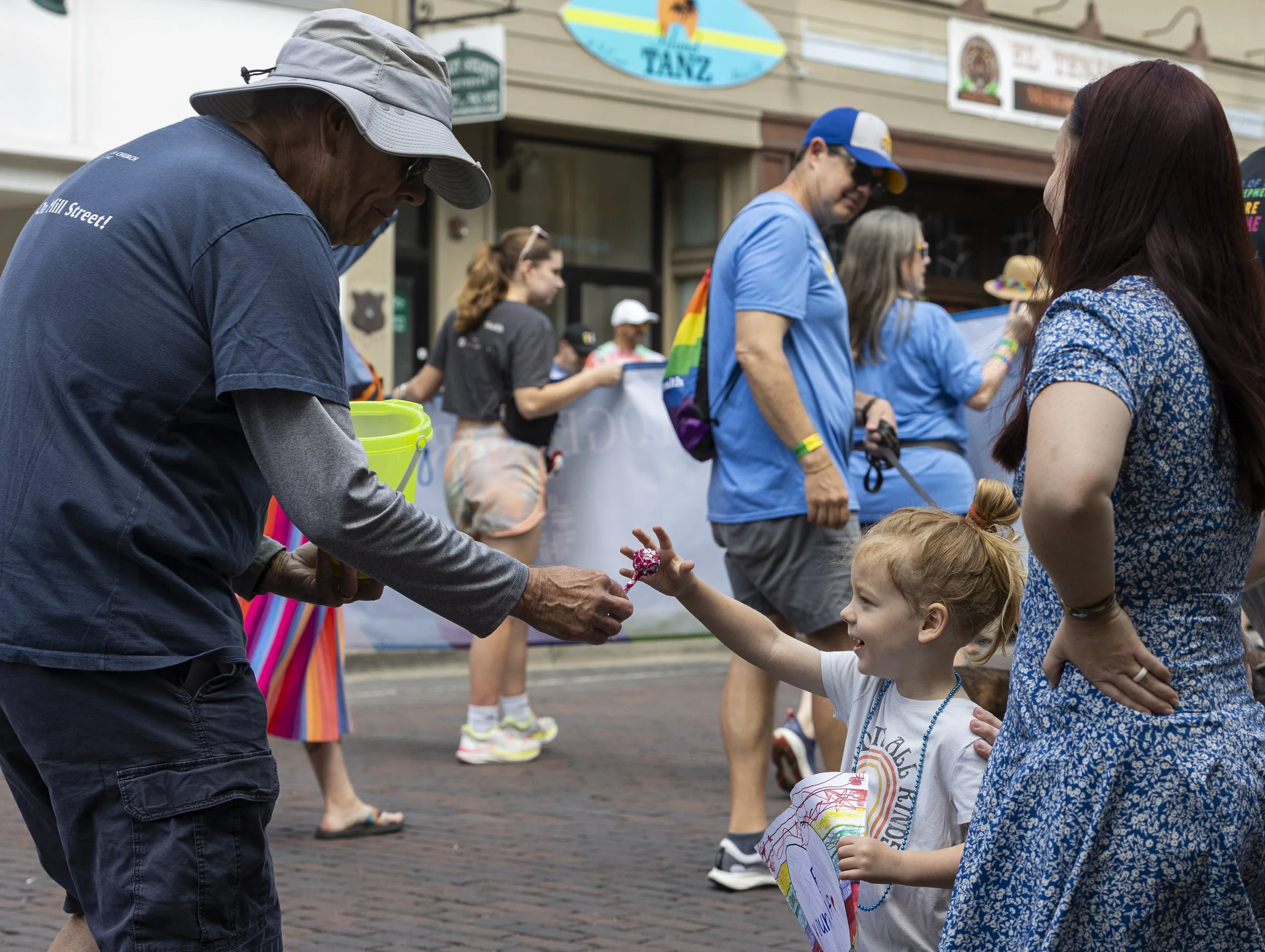 A member of the Christ Lutheran Church marching in the Athens Pride Parade hands a child a lollipop on Court Street in Athens, Ohio, June 6, 2026. | For The Post
