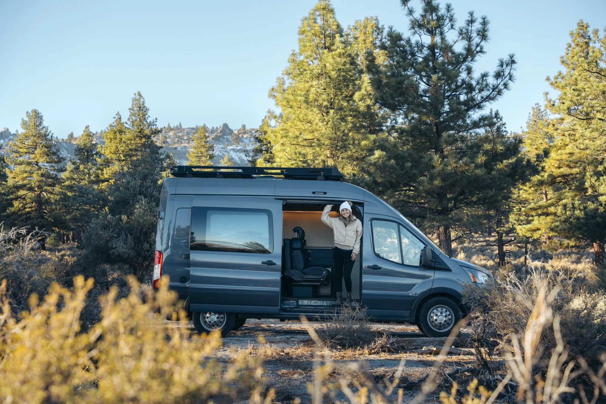 Capitan Camper Van | FOG Campers | Jess Linderman | Exterior side with model hanging out along side door.jpg