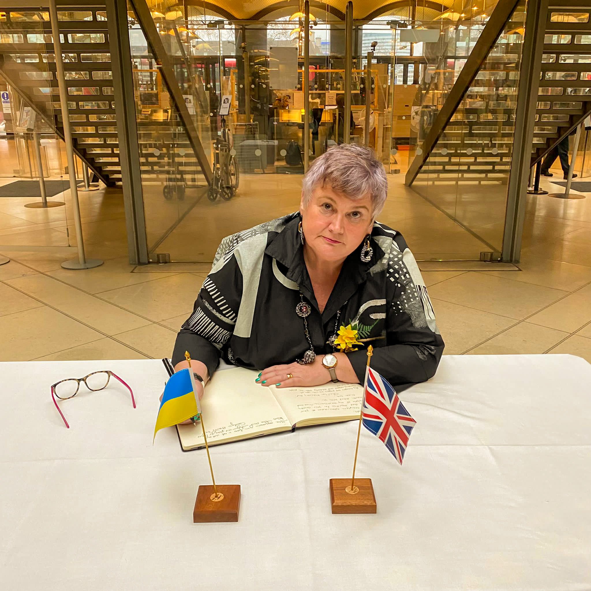 Carolyn signing the book of condolences and solidarity following Russia's invasion of Ukraine