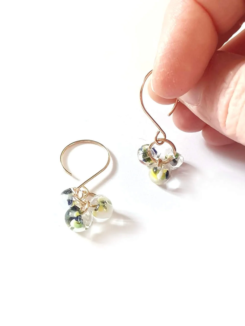 handheld image to illustrate the size of the seasonal earrings grass