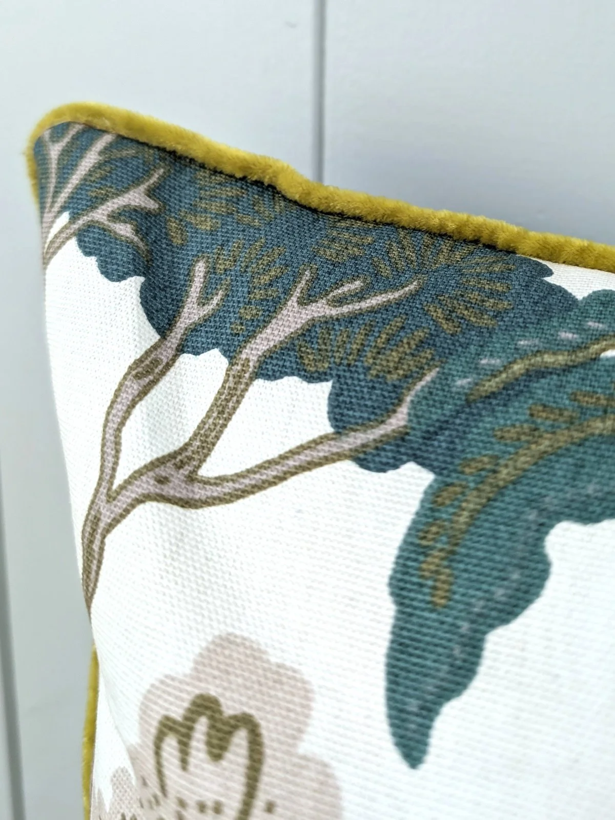 corner detail of forest print cushion with piping
