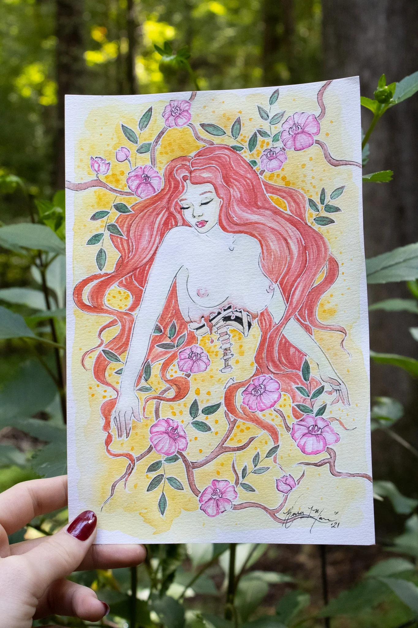 A watercolor illustration of a woman with long, flowing red hair surrounded by pink flowers and green leaves.