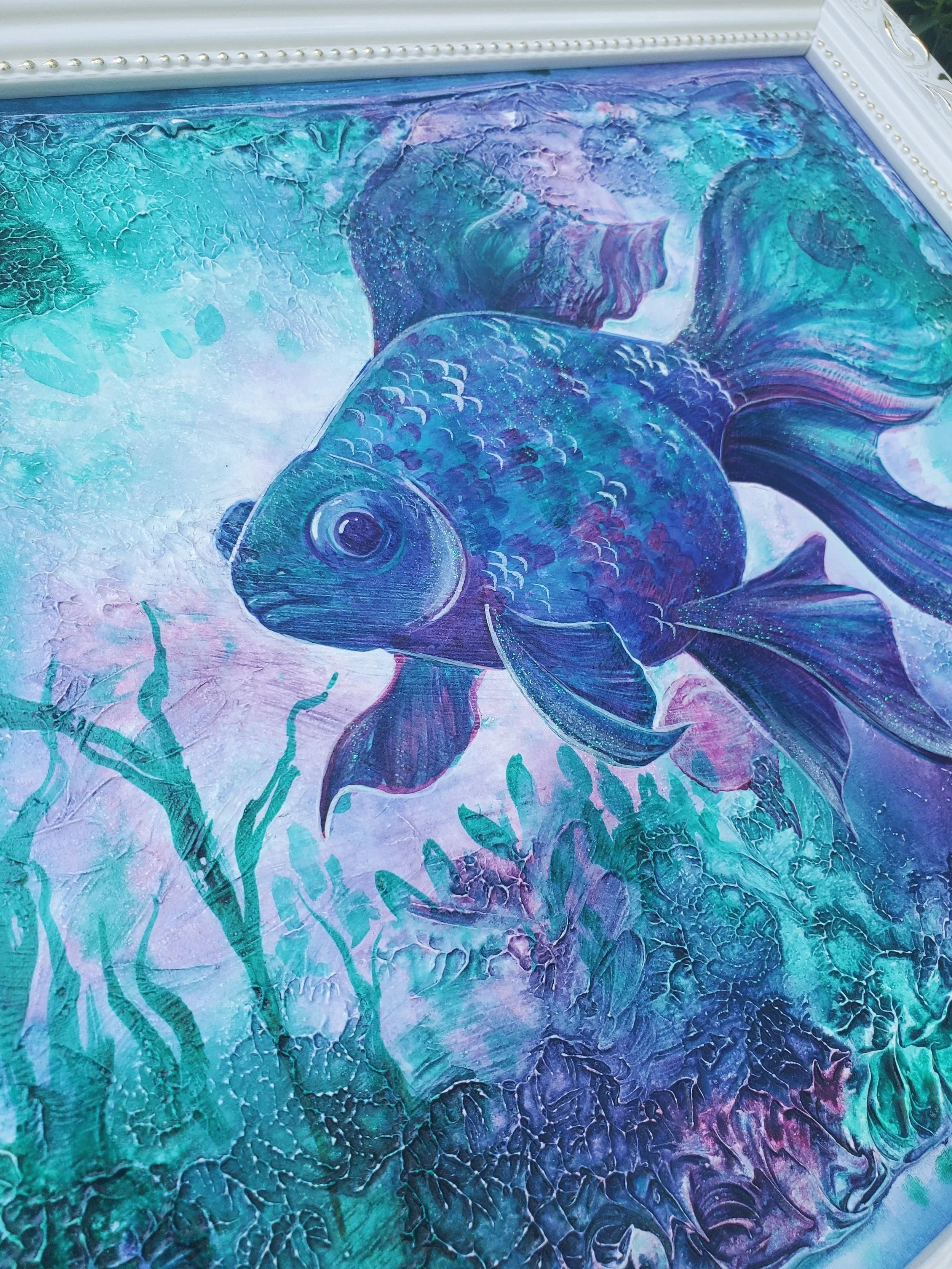 A colorful abstract painting featuring a fish with flowing fins, surrounded by aquatic plants and textured background in shades of blue, green, purple, and pink.