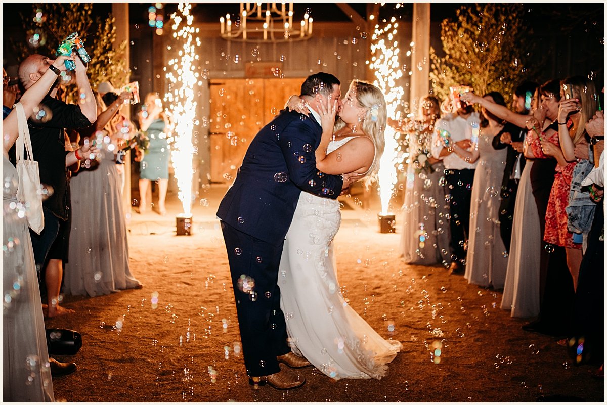 Bride and groom kissing during bubble grand exit | Lauren Crumpler Photography | Texas Wedding Photographer