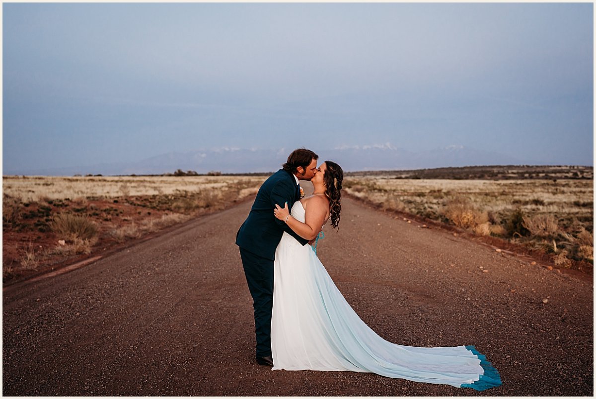 Bride and groom wedding portraits on a dirt road with mountain backdrop at dusk | Lauren Crumpler Photography | Elopement Wedding Photographer