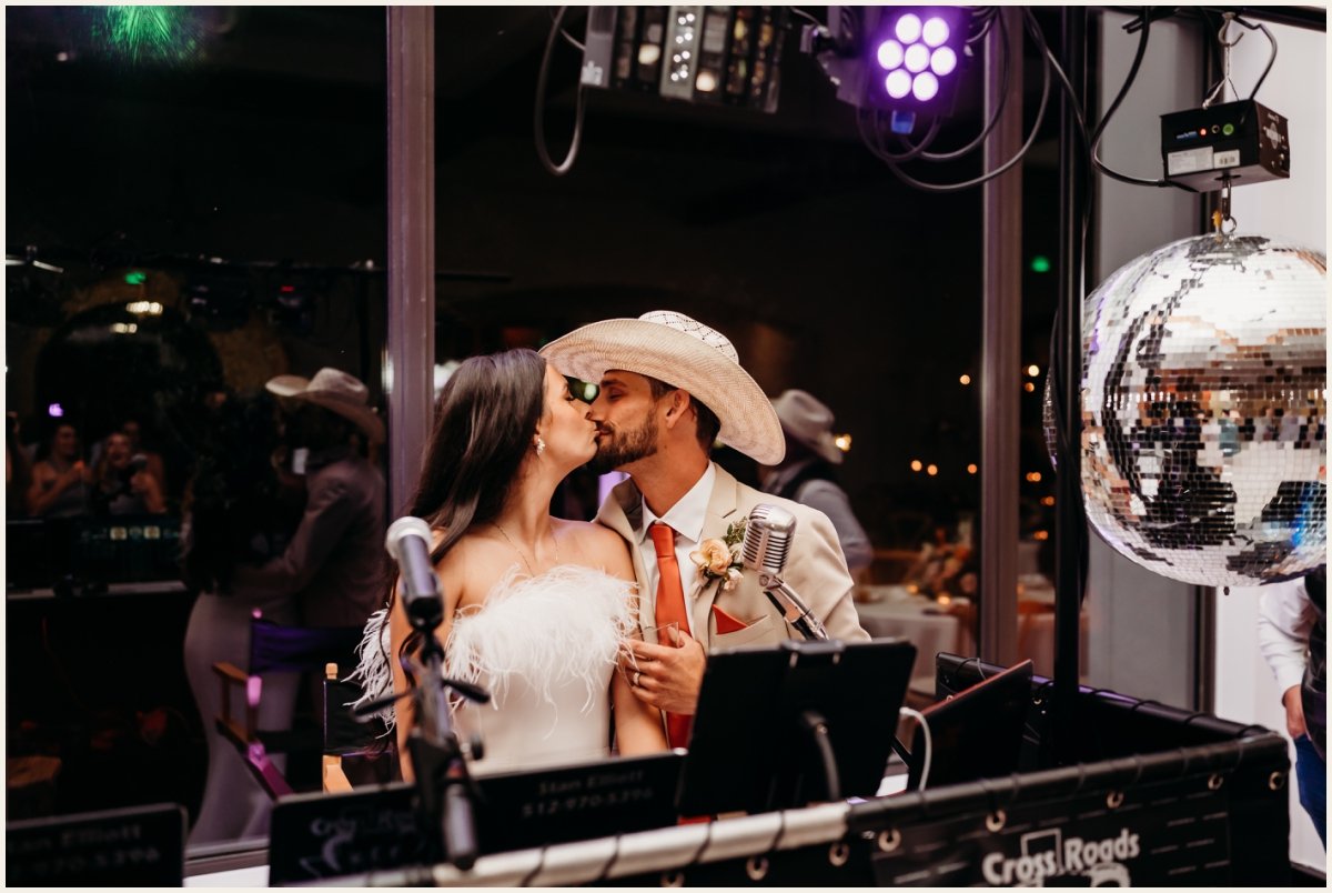 Bride and Groom kissing behind the DJ Booth | Lauren Crumpler Photography | Texas Wedding Photographer