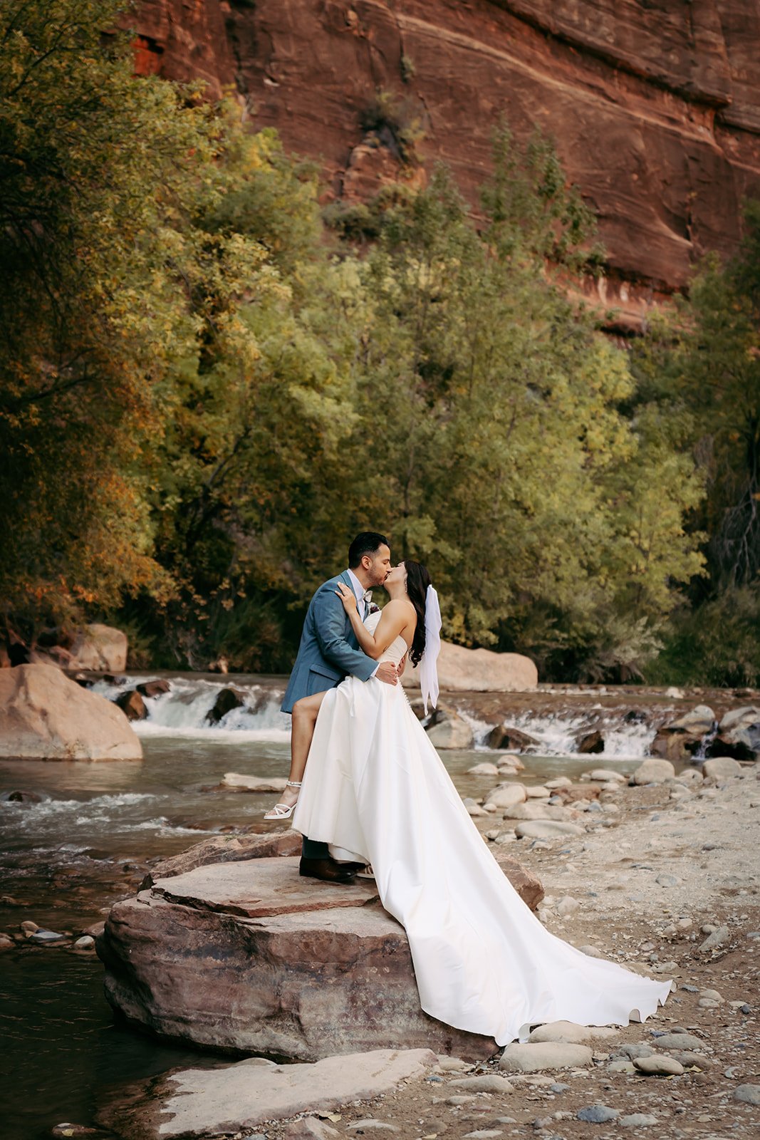  gorgeous couple kissing each other with a river in the back 