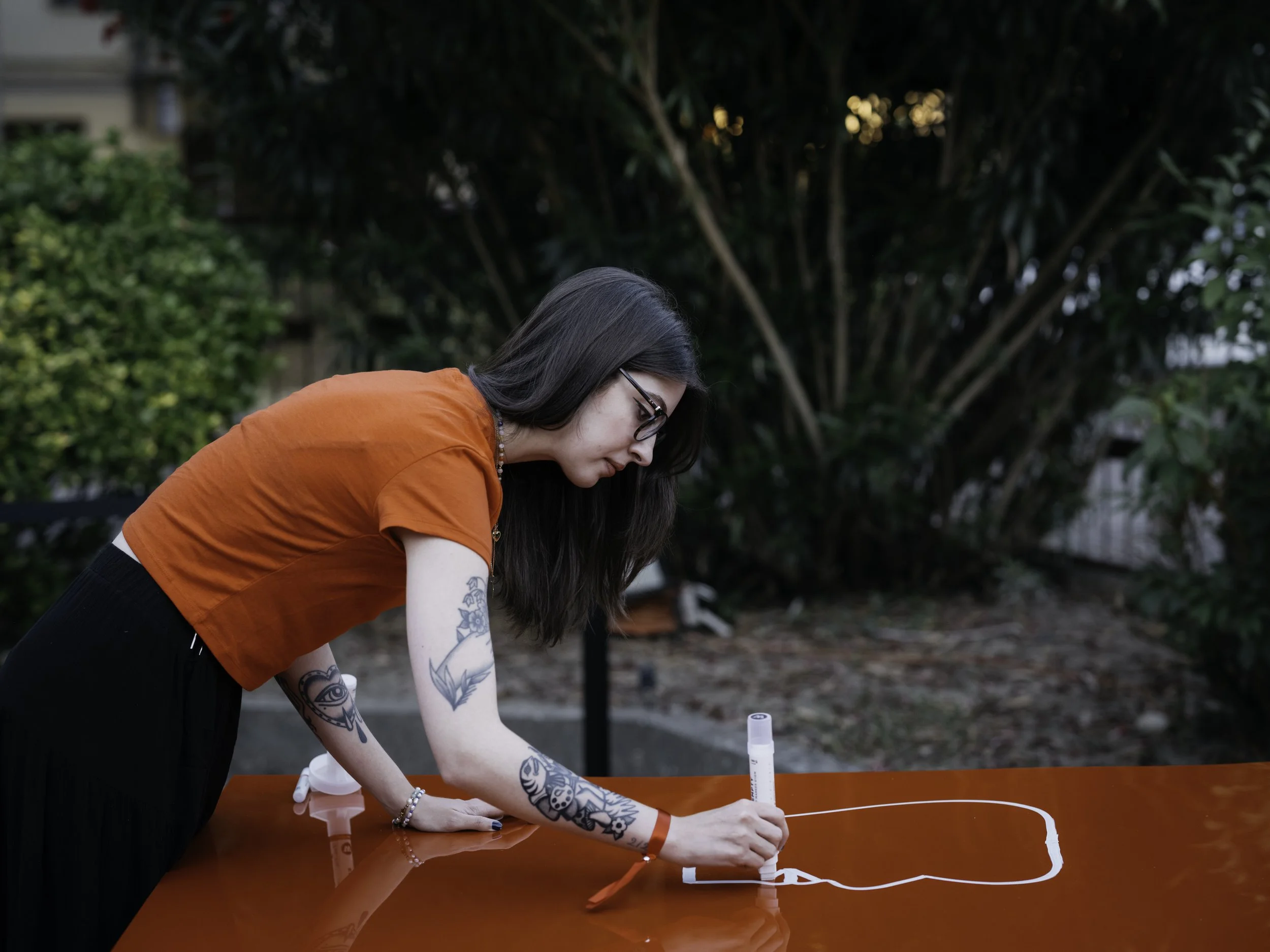 Illustratrice disegna su un pannello rosso con un pennarello per un'esibizione ad un evento