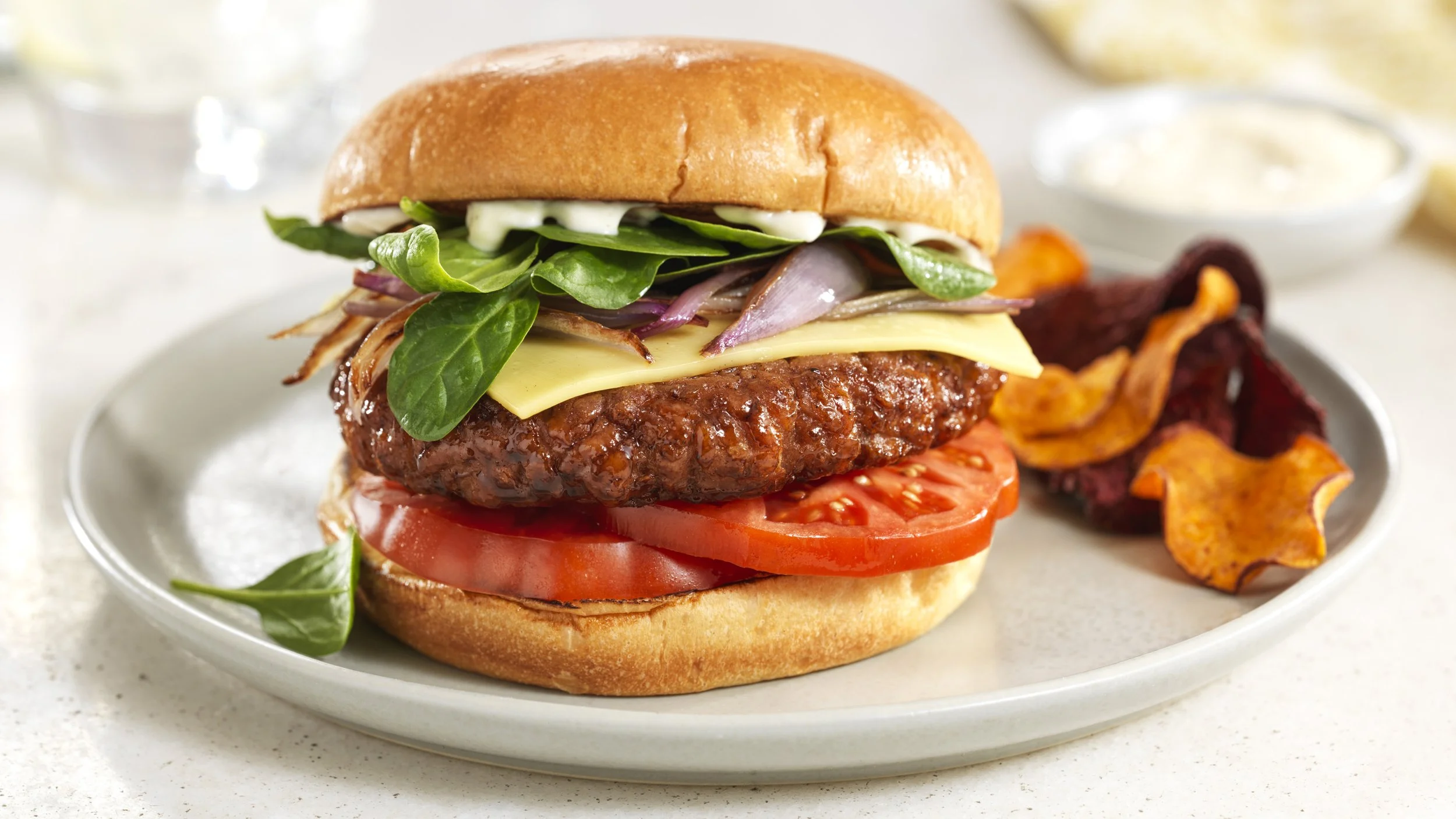 Lightlife plant-based burger topped with Chao plant-based cheese with tomato and spinach recipe image