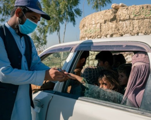 A polio vaccinator immunizes a girl at a checkpoint in Achin, Afghanistan’s northeastern poliovirus epicenter. (Elise Blanchard for The Washington Post)