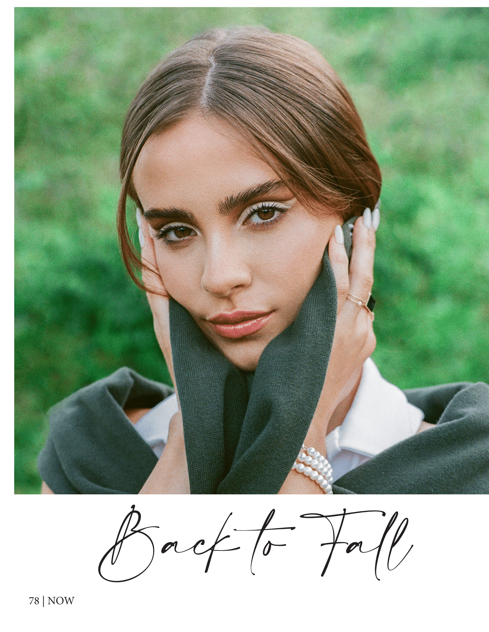 Close-up of a woman with long hair, wearing a sweater over her shoulders, holding a scarf near her face, with a pearl bracelet on her wrist against a green blurred background. Text "Back to Fall" at the bottom.