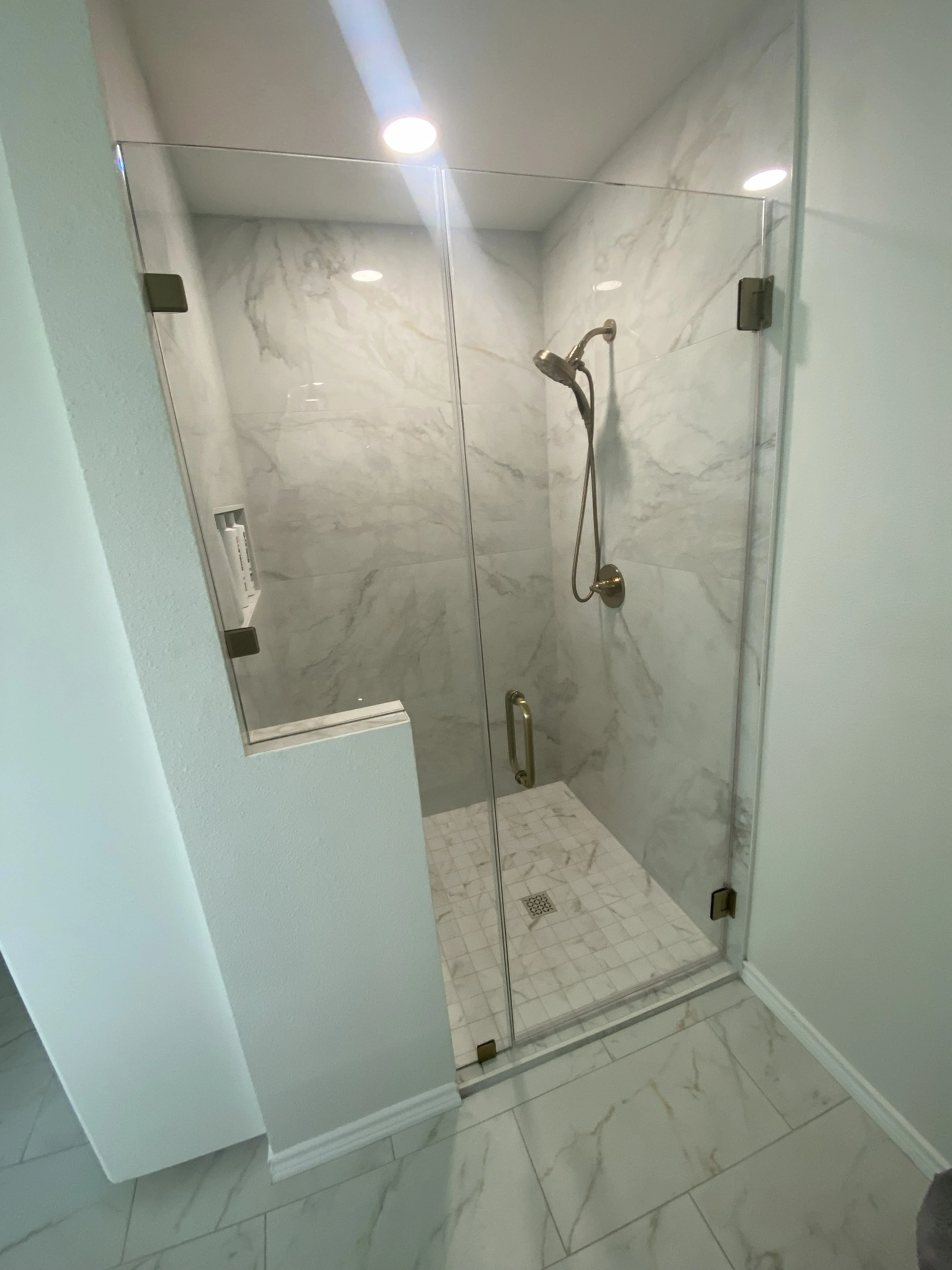 College Station HAL Nantucket Master Bath remodel, Calcatta tile and countertops with champagne bronze fixtures 6.jpg