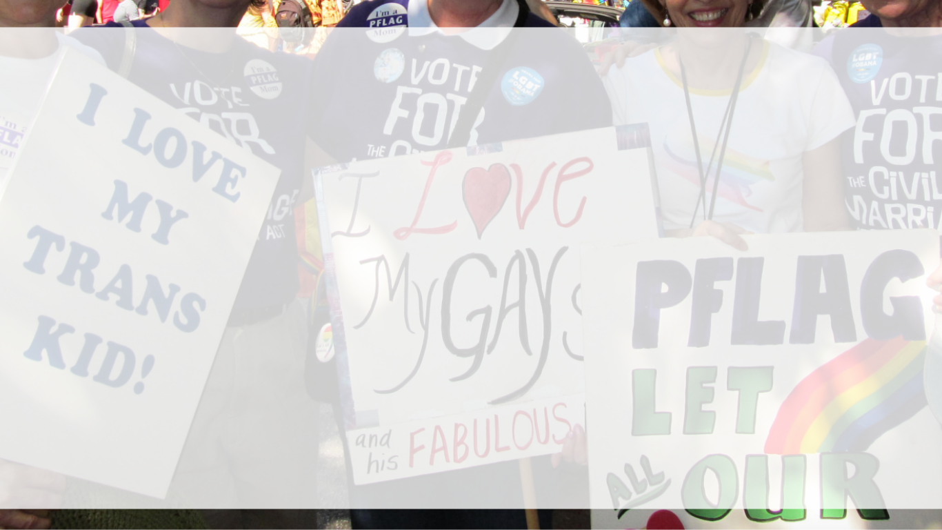 Photo of Parents of PFLAG holding signs support their children with a white banner overlay.