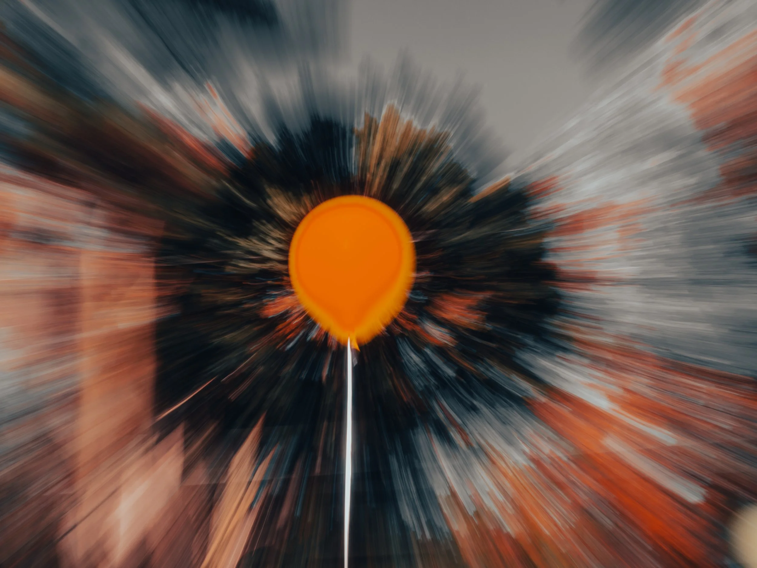 A photo of a sunset with a hot air balloon in the foreground, with motion blur effect surrounding the balloon.