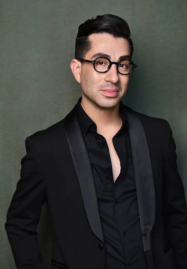 Serious theatrical headshot of a male actor in a black tuxedo and round glasses, Los Angeles photography by Marc Cartwright.