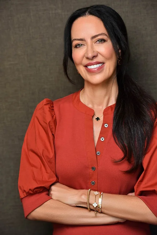 Corporate Photography, Executive Portraits and Business Headshots Los Angeles - This high-quality business headshot features a confident, approachable woman with long dark hair, styled simply and elegantly. She is dressed in a stylish rust-colored bl