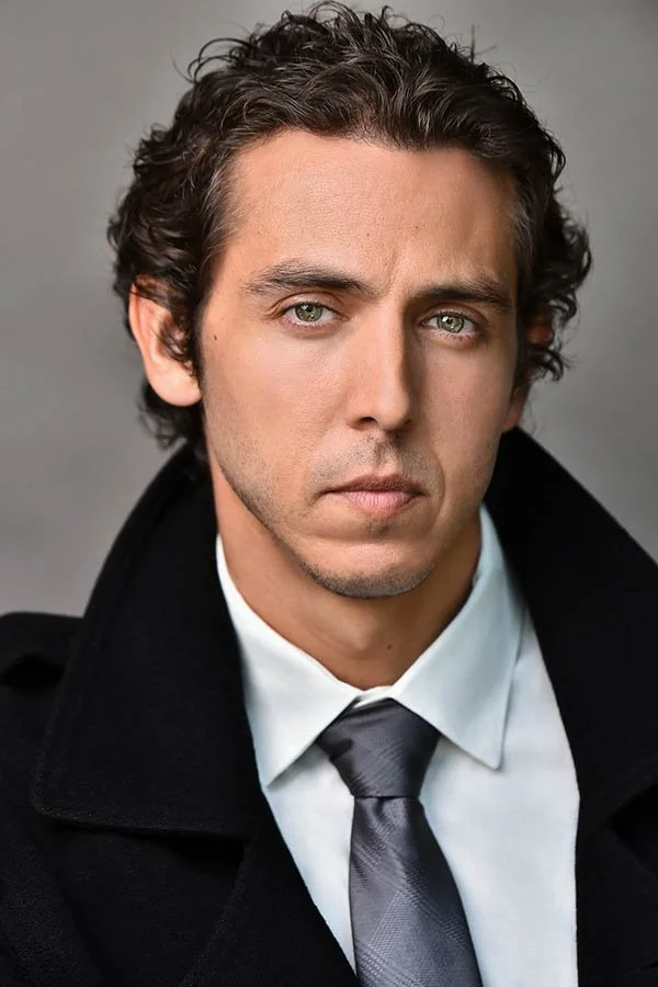 Professional corporate headshot of a clean-shaven male business man in a white dress shirt, grey tie, and black overcoat with a serious expression. Ideal for linkedin, company websites and executive portraits in Los Angeles, photographed by Marc Cart