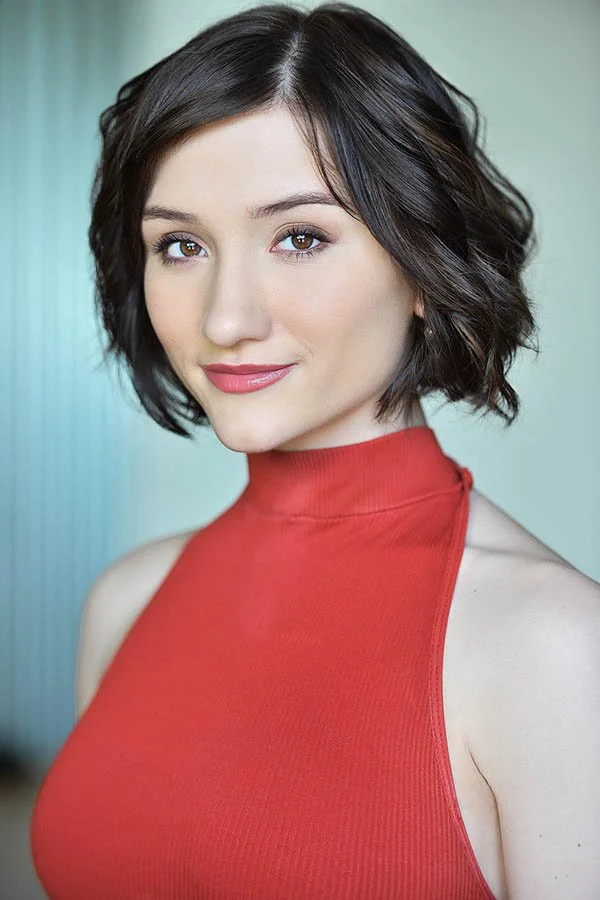 Actor headshot photographed by Marc Cartwright in Los Angeles, featuring a woman with short dark hair in a coral top, shot in soft natural light for professional film and TV headshots.