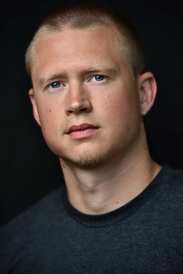 Dramatic male actor headshot with clean framing and neutral background, photographed in Los Angeles.