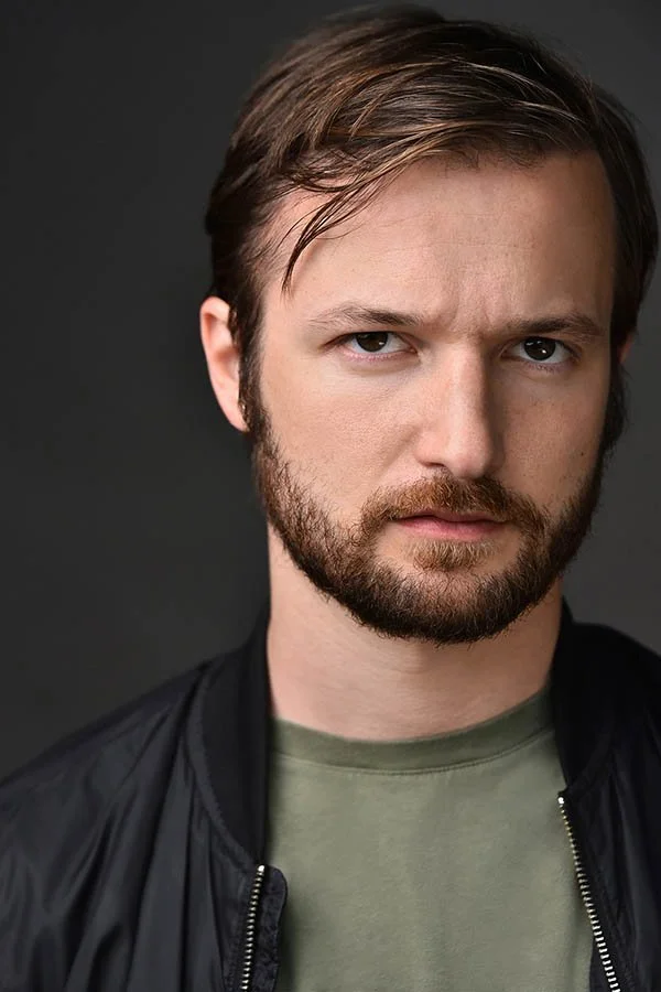 Male actor headshot with an intense, focused expression against a dark background, photographed by Marc Cartwright Headshots in Los Angeles.