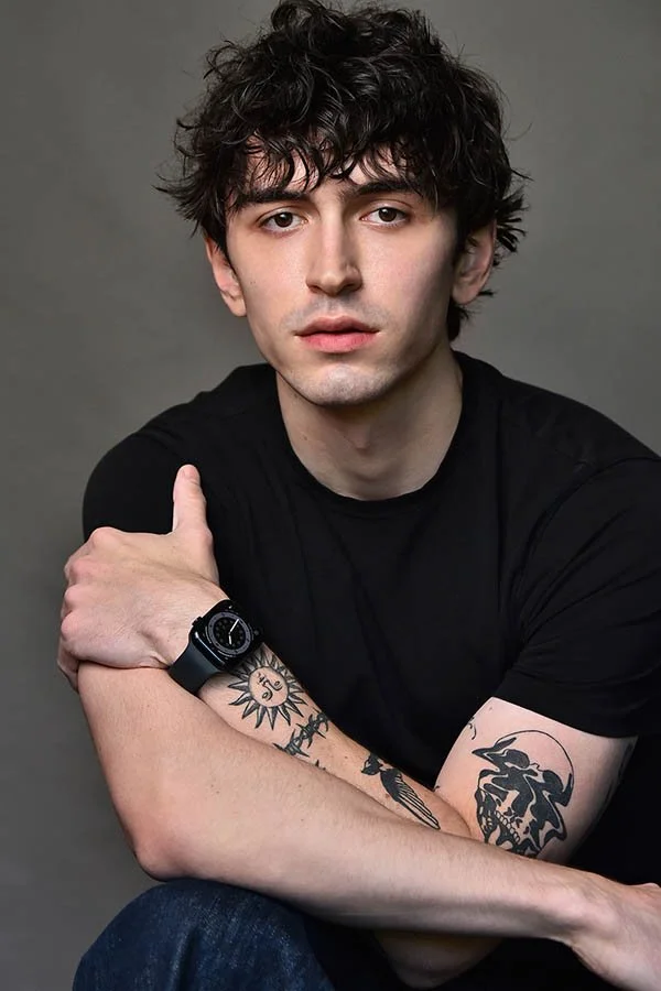 Male actor with arm tattoos in a black t-shirt seated for character headshots in Studio City, LA by Marc Cartwright