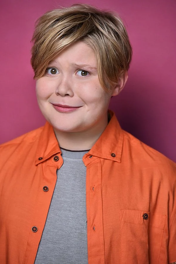 Comedic teen actor headshot with expressive personality and colorful backdrop, photographed by Marc Cartwright Headshots in Studio City, Los Angeles. Ideal for sitcom and youth commercial casting.
