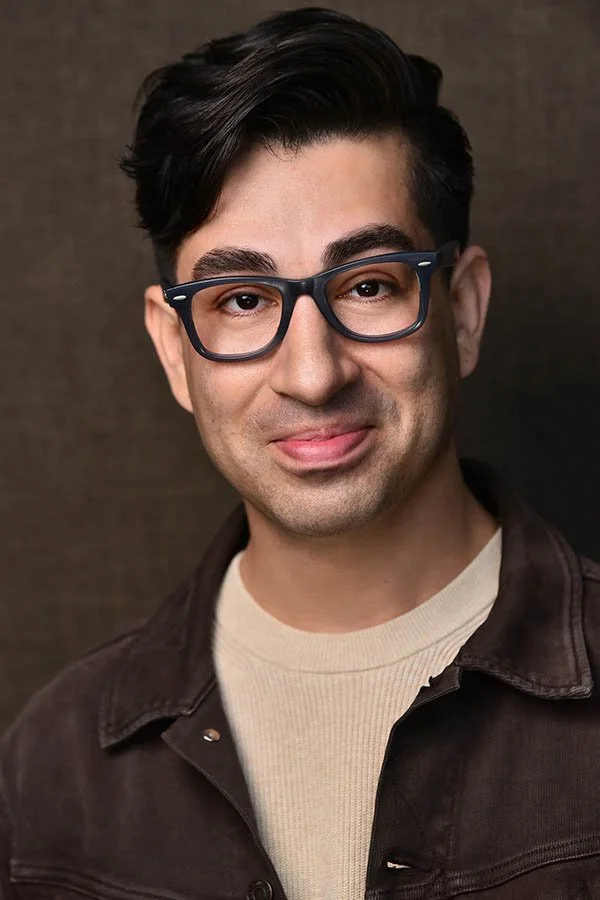 Sophisticated male headshot featuring a brown jacket and intellectual glasses, professional actor photography in Hollywood.