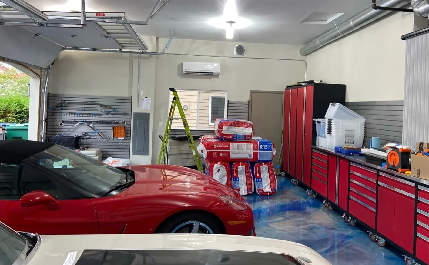 Bothell garage after drywall finishing and painting, showing smooth light-colored walls and ceiling above gray wall storage panels.