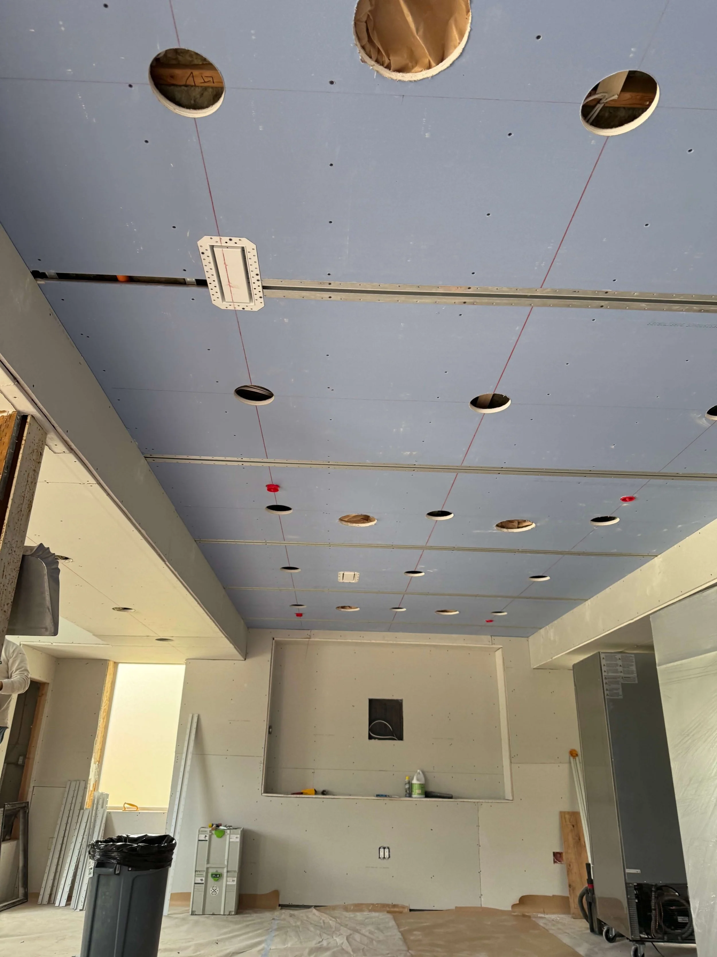Ceiling drywall installation in Redmond with reglet channels prepared for continuous shadow reveals.