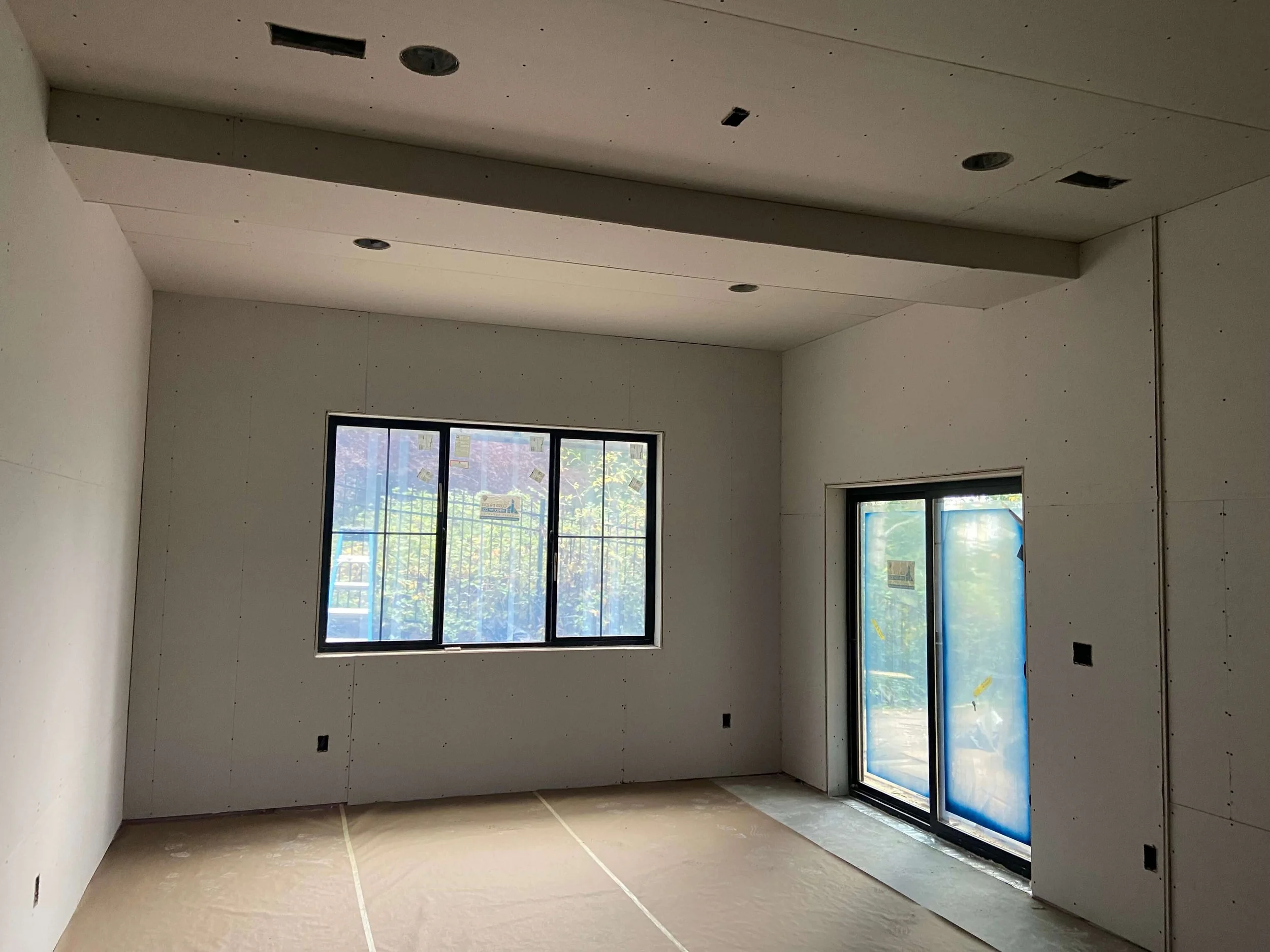 New drywall installed on the walls, ceiling, and soffits of a Snohomish basement before finishing.