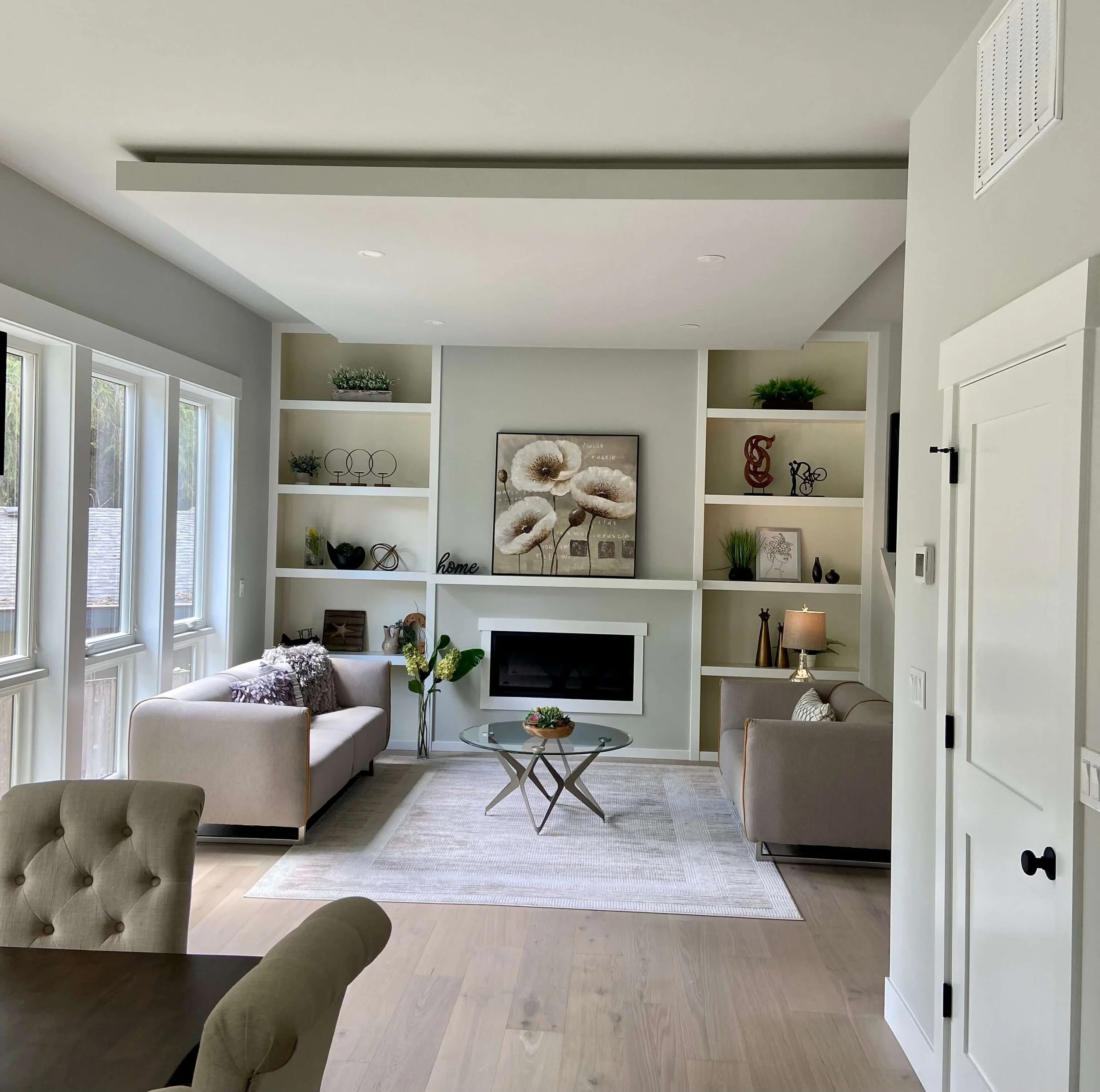 Finished custom-home living room in Kenmore with Level 5 drywall, PVA primer, interior paint, built-in shelving, and detailed ceilings.