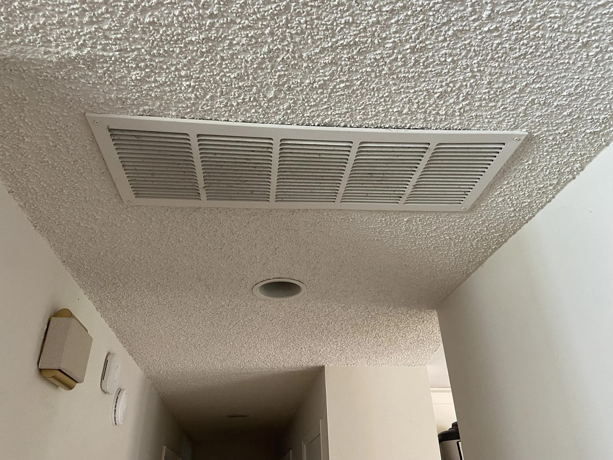 Wetting popcorn ceiling texture to reduce dust and clump debris in Mercer Island and Woodinville homes — L.A. Drywall Inc.