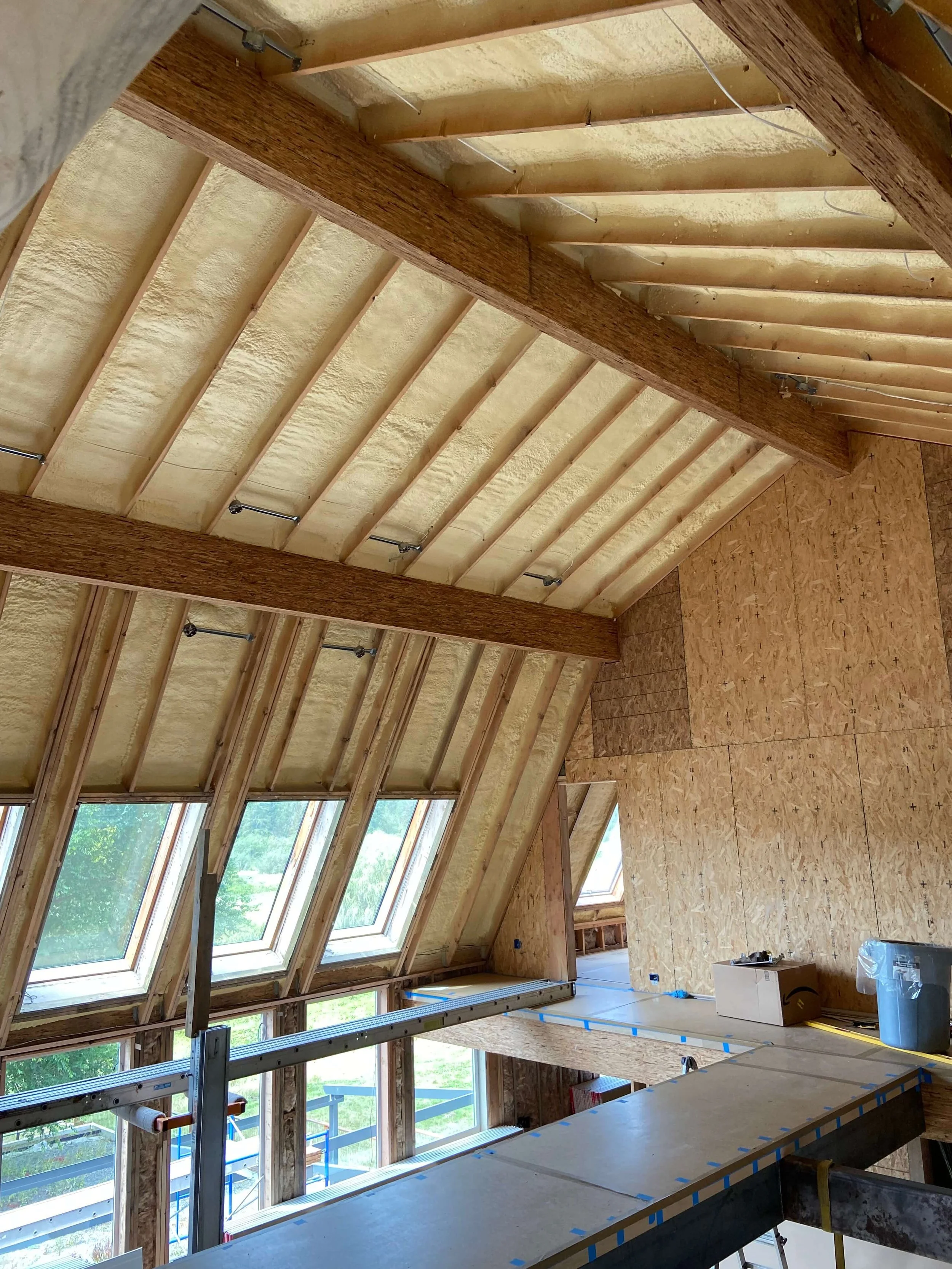 Exposed framing, insulation, skylights and wood beams before drywall installation in a Redmond loft remodel.
