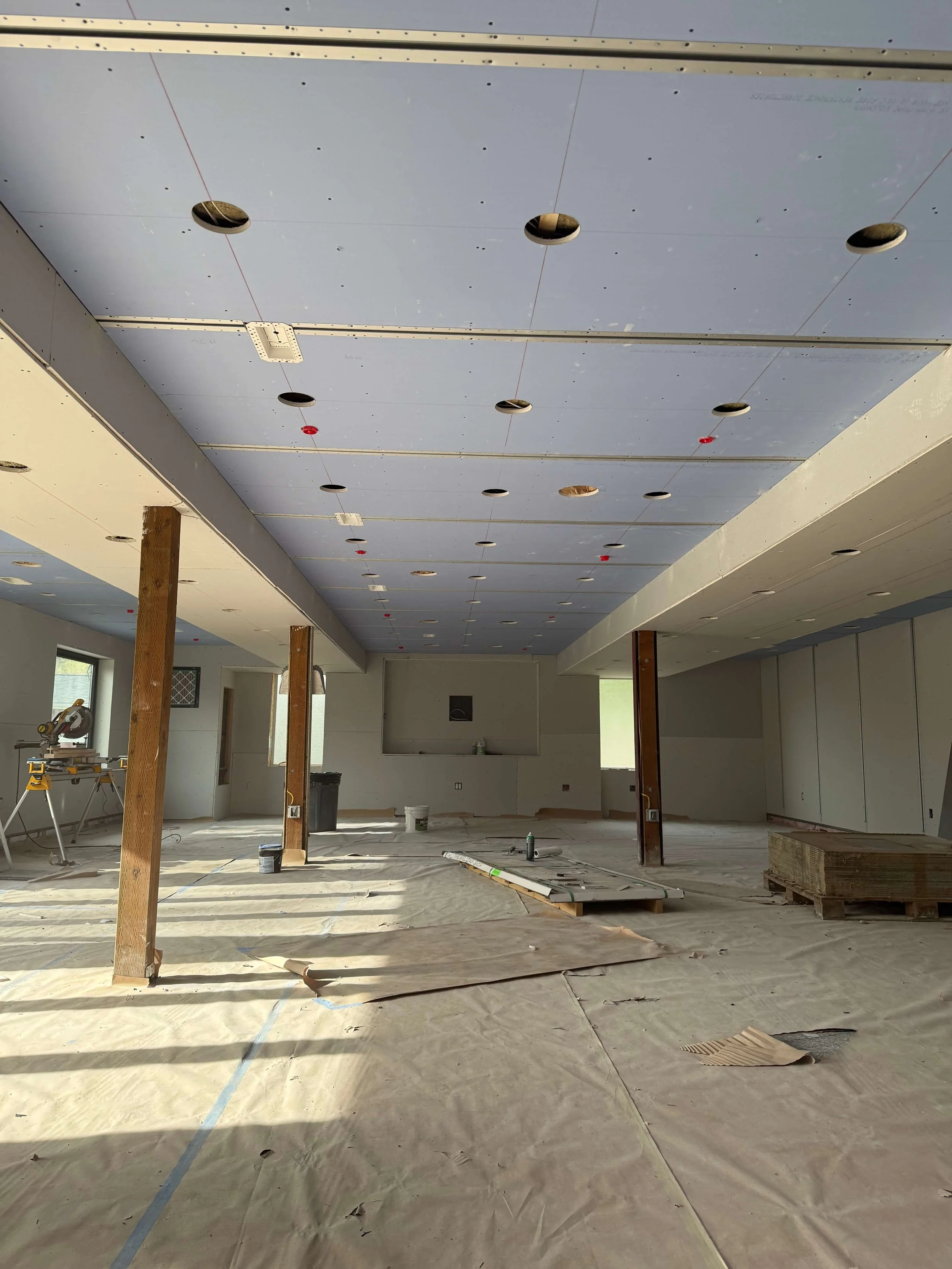 Large Redmond interior during architectural ceiling drywall installation before Level 5 finishing and recessed details.