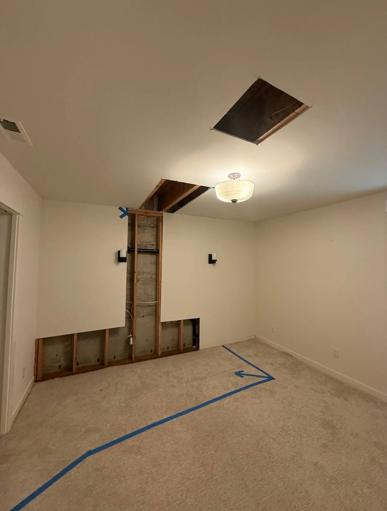 Before drywall repair in a Kirkland WA basement showing wall damage and exposed framing prior to finishing.