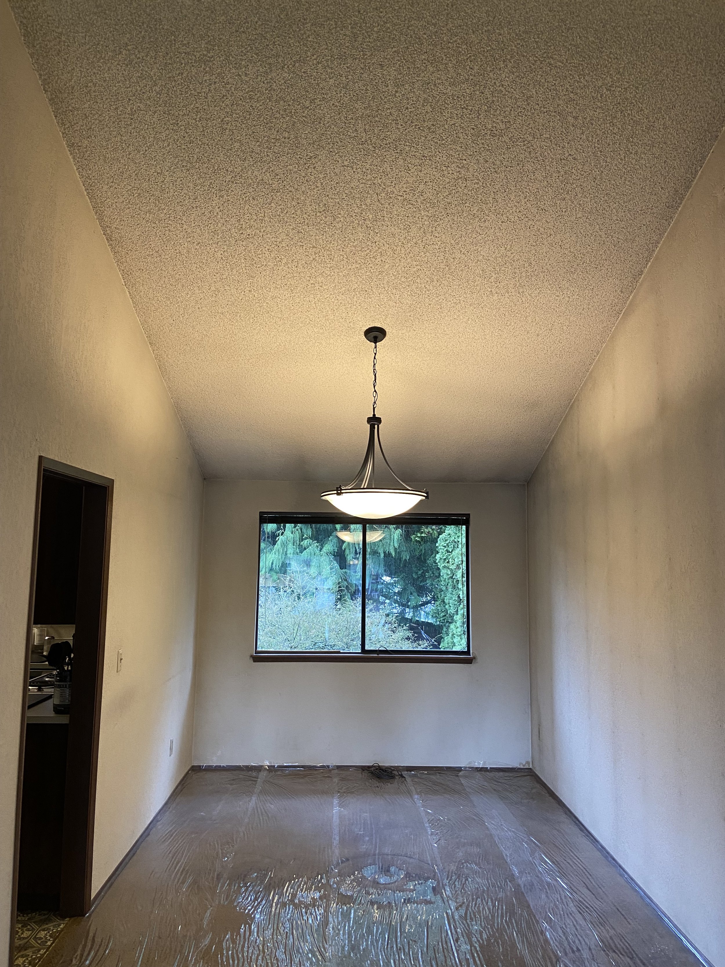 Popcorn ceiling removal floor protection with plastic and heavy-duty paper in Bellevue and Everett homes — L.A. Drywall Inc.