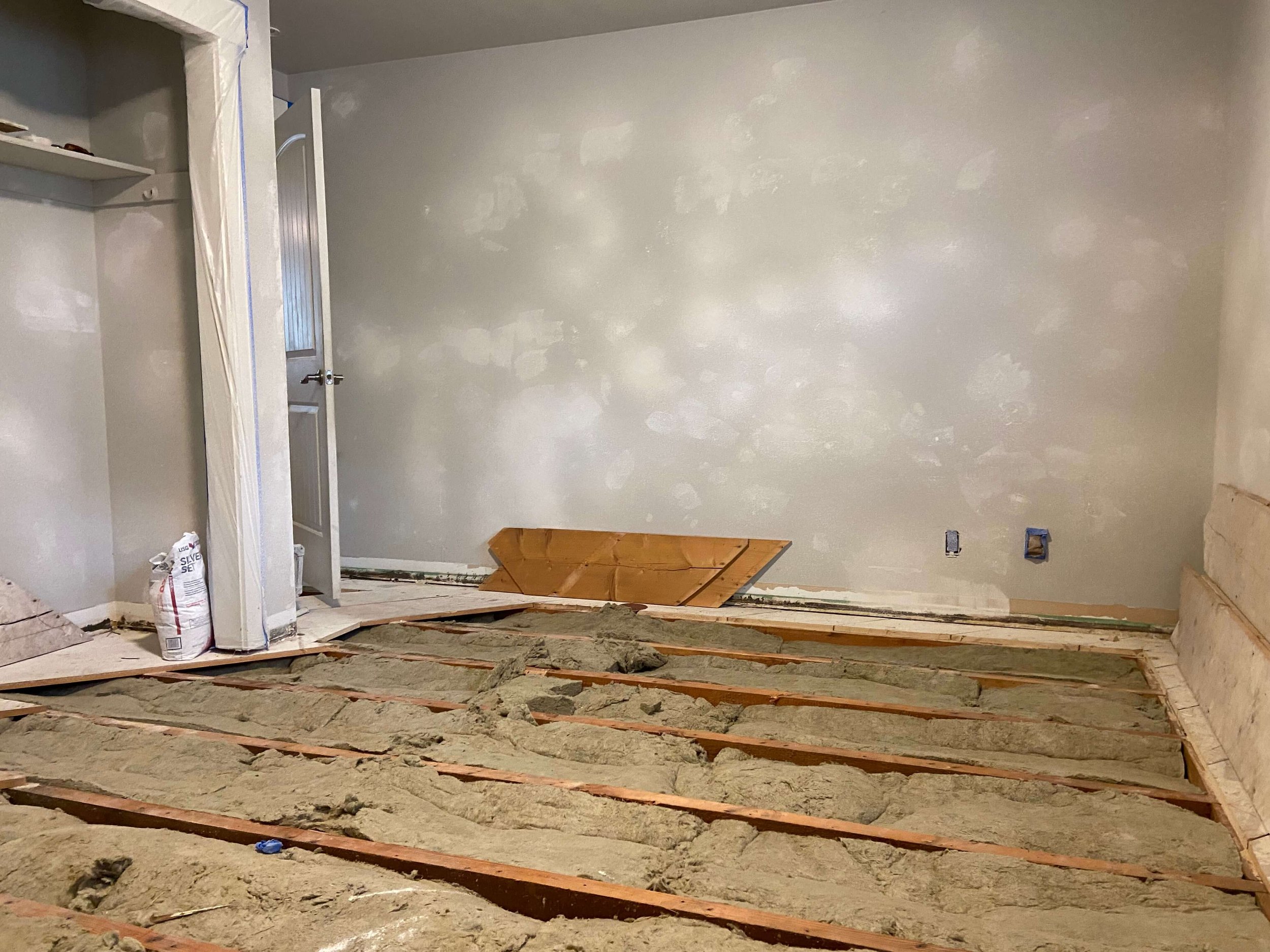 Before drywall repair in a Bothell WA home showing damaged walls and exposed subfloor prior to restoration and finishing.