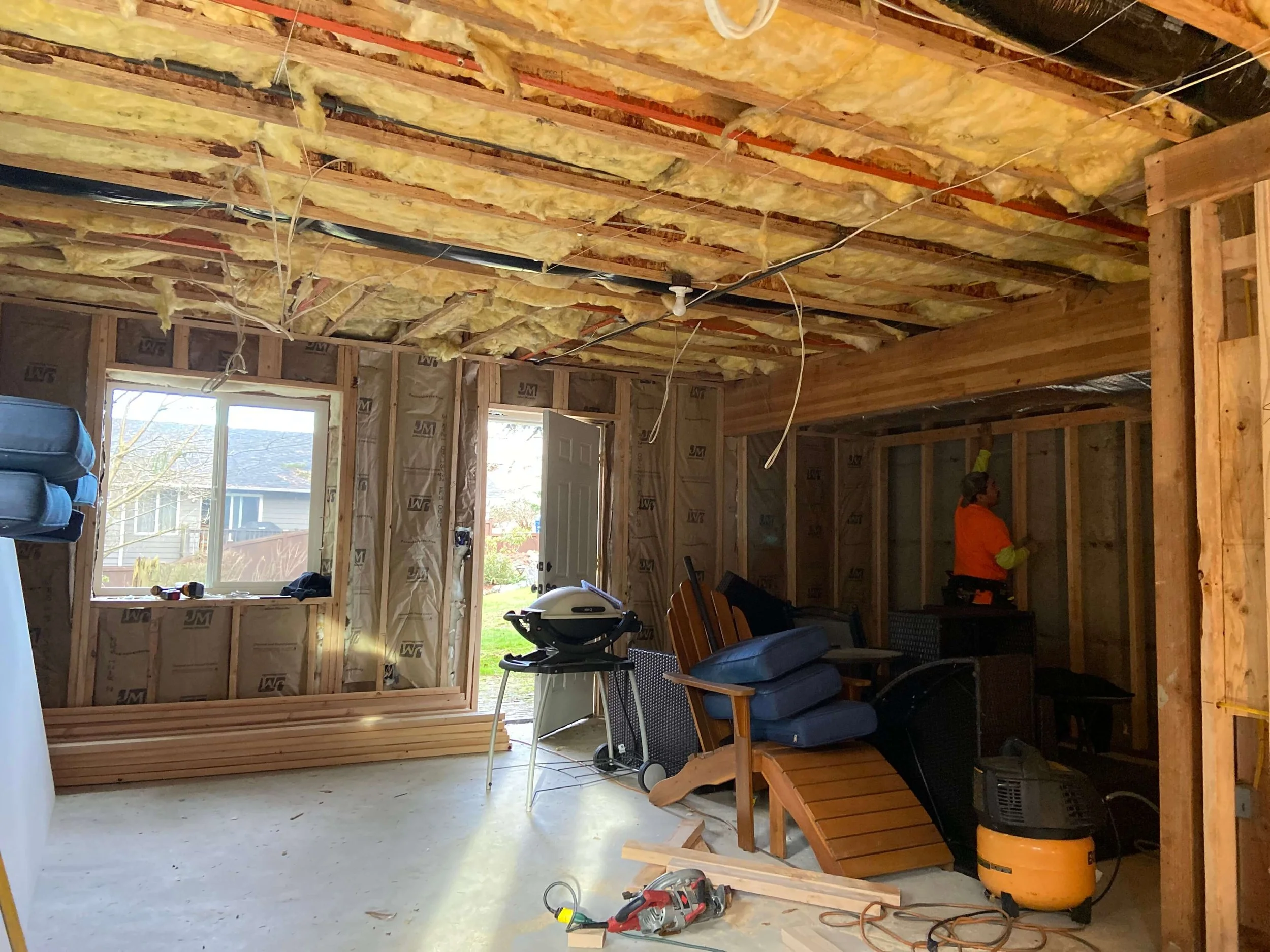 Unfinished Lynnwood basement with exposed wall framing, ceiling joists, and insulation before drywall installation.