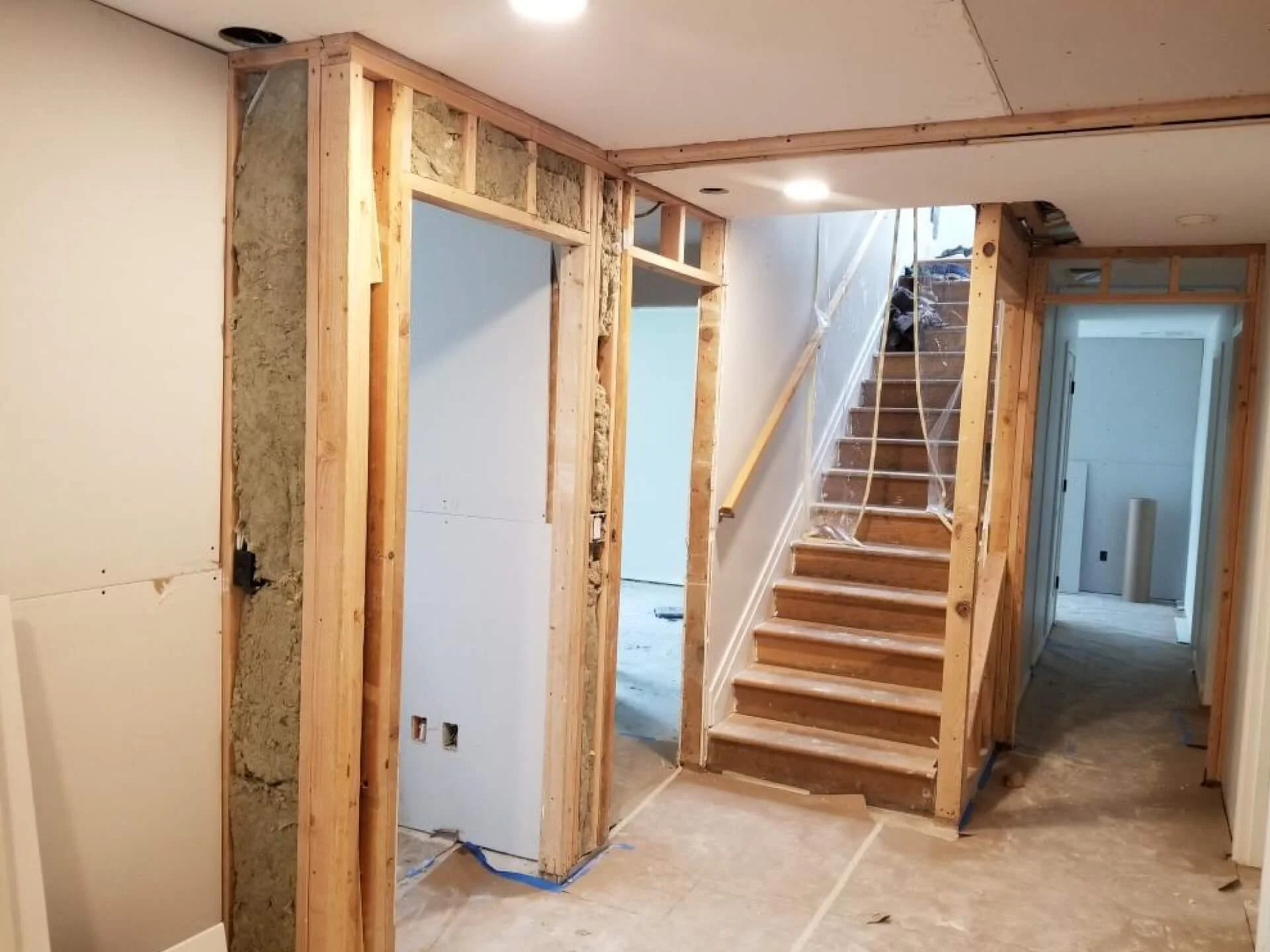 Before drywall work in a Mercer Island basement remodel with exposed framing around the hallway and stairwell.