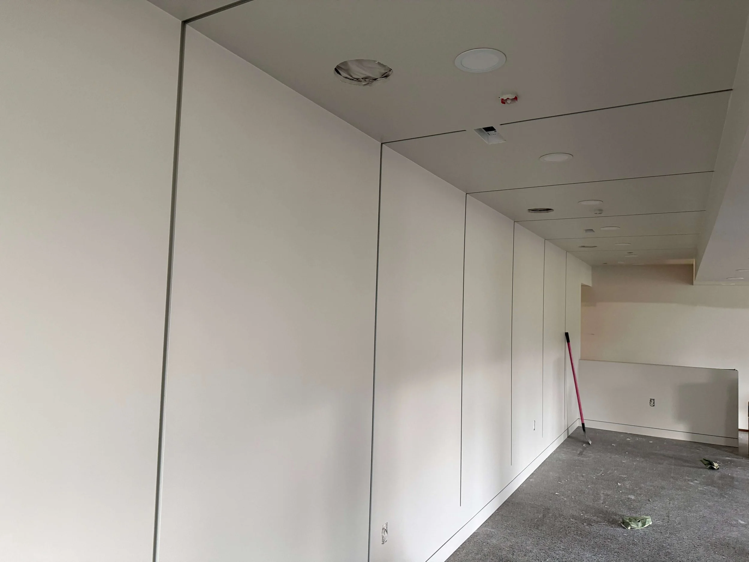 Finished architectural drywall in Redmond with continuous shadow reveals across the walls and ceiling.
