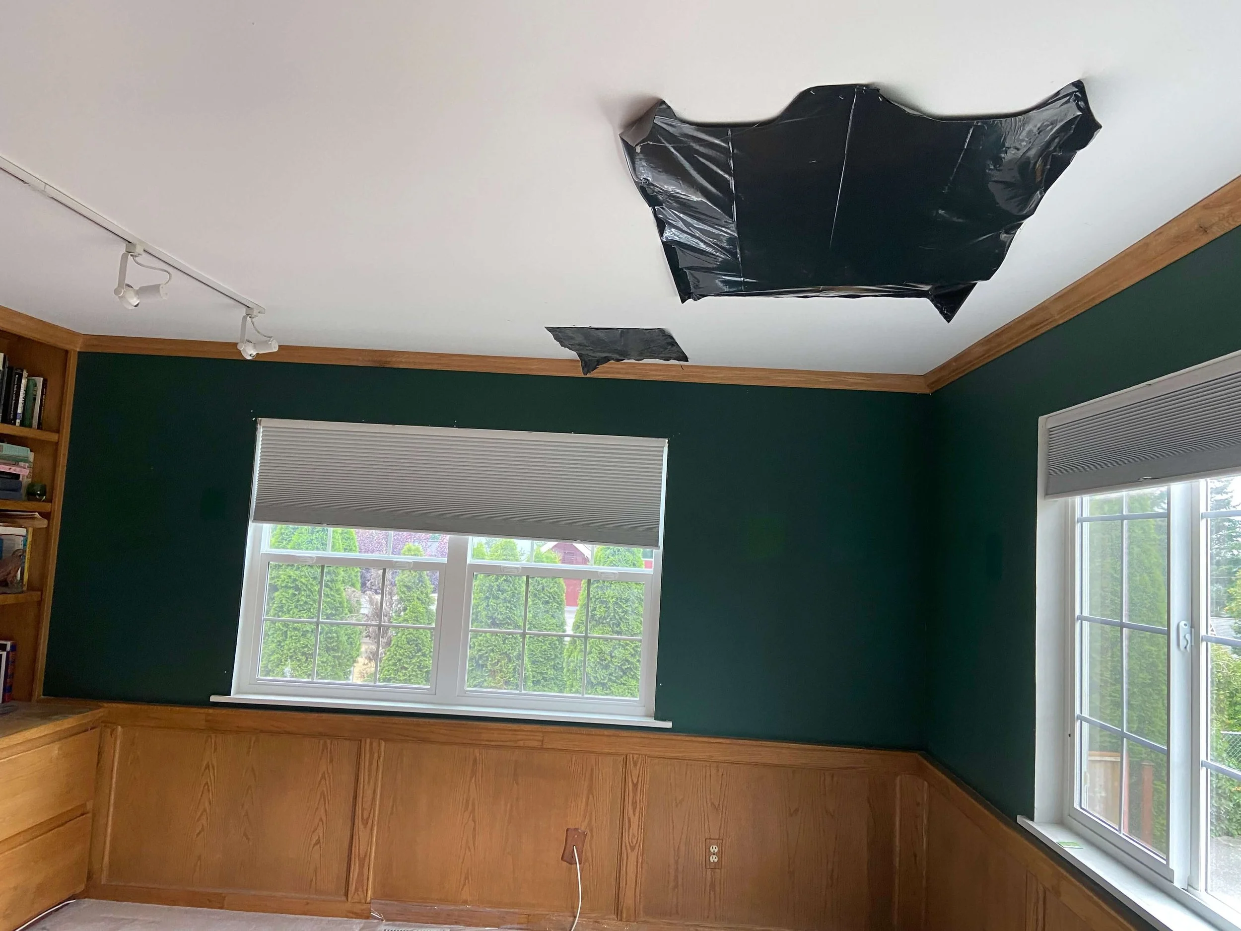 Bellevue room before ceiling drywall repair with an opened damaged area above built-in cabinetry