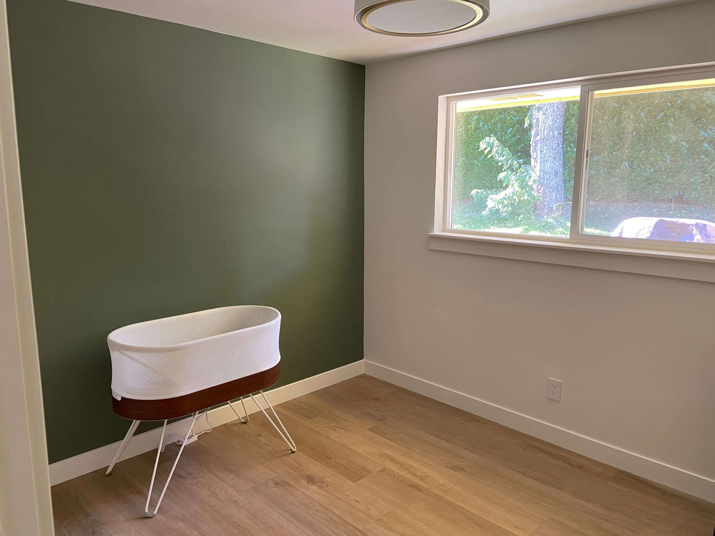 Restored Redmond bedroom with smooth repaired walls, green accent paint, white trim and finished flooring.
