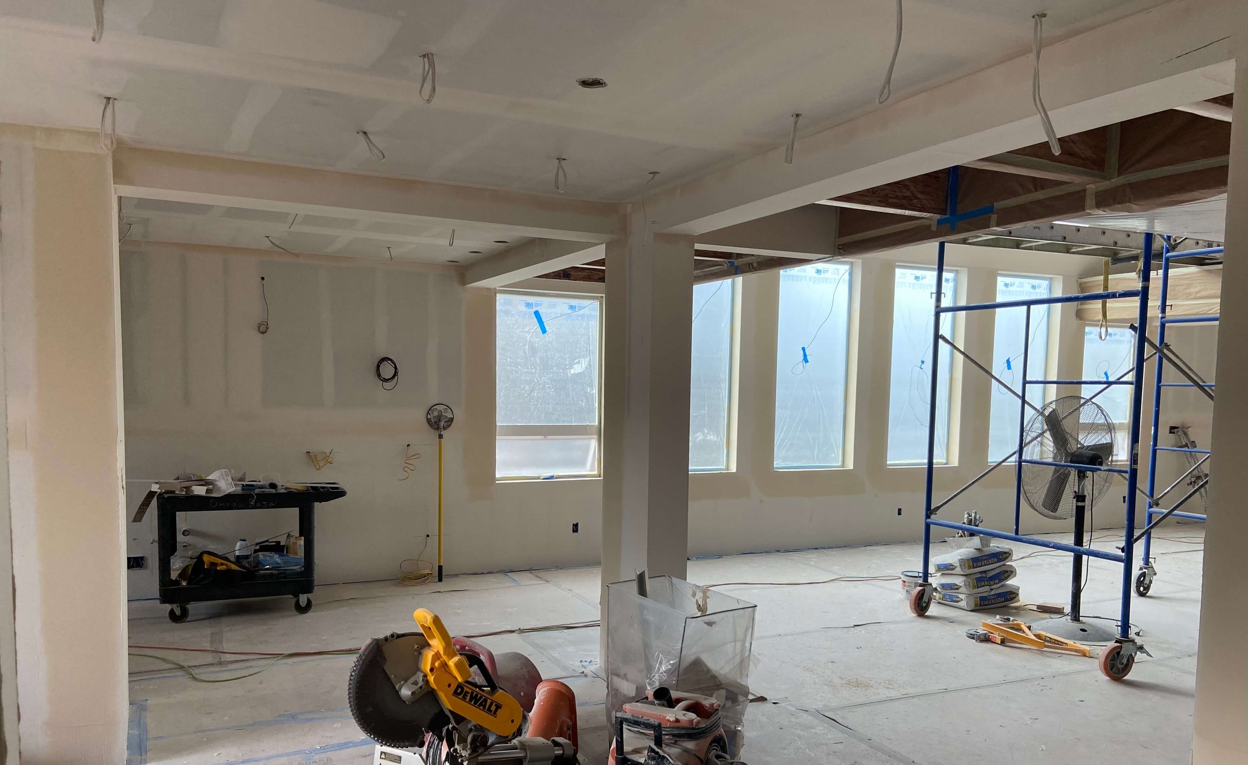 Redmond whole-home remodel during drywall finishing, with taped walls and ceiling, scaffolding, and an open ceiling area.