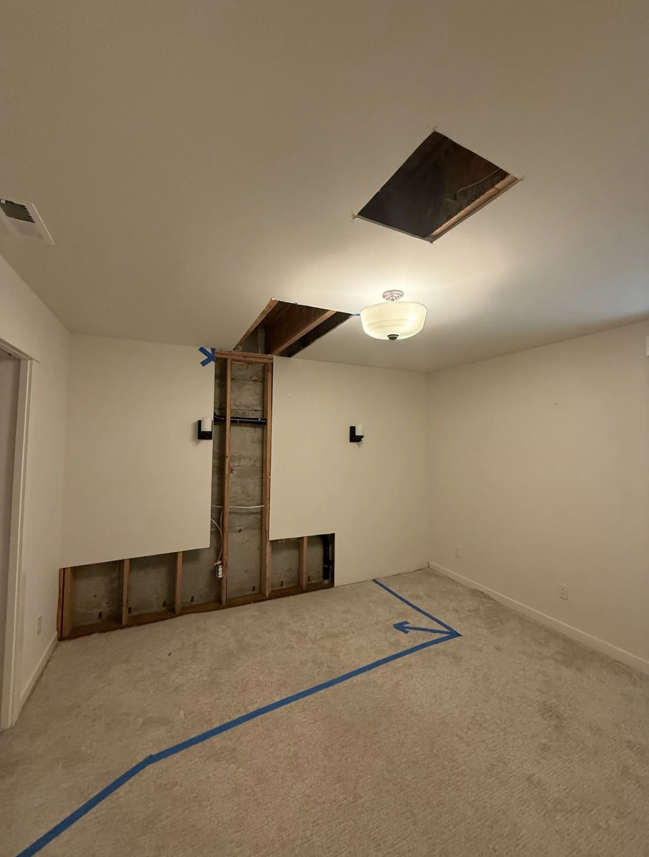 Before basement drywall repair in Kirkland WA showing wall openings and exposed framing.
